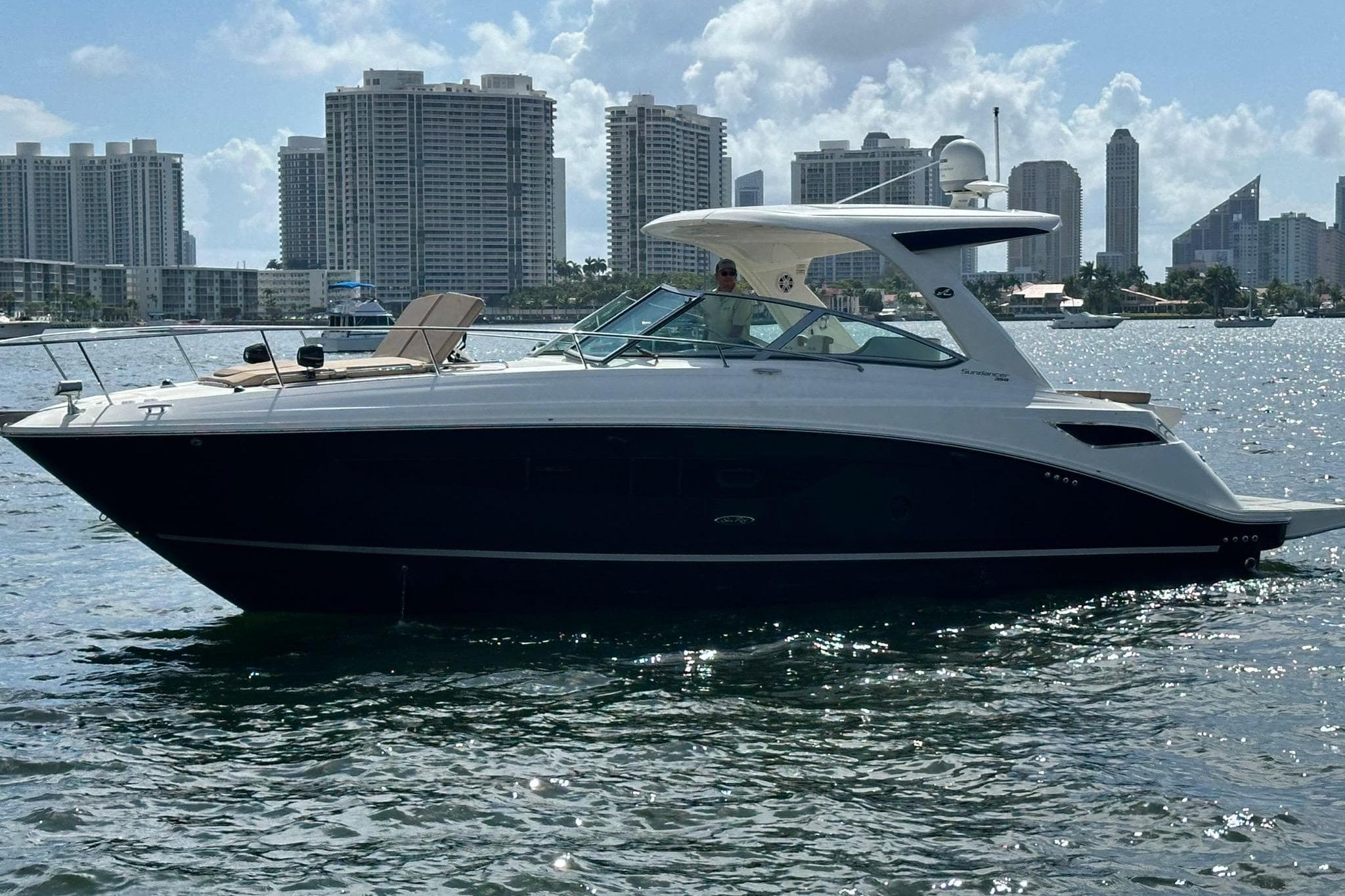 2016 Sea Ray 350 Sundancer yacht cruising near city skyline.