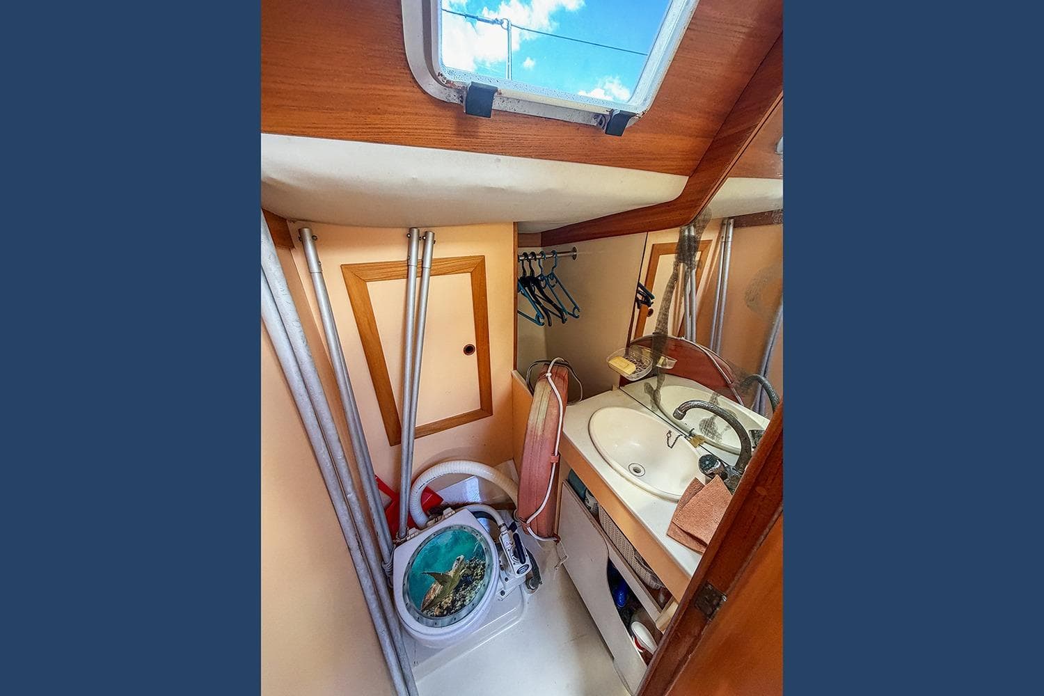 Compact bathroom interior of 1987 Kirie Feeling 1350 sailboat with sink and storage.
