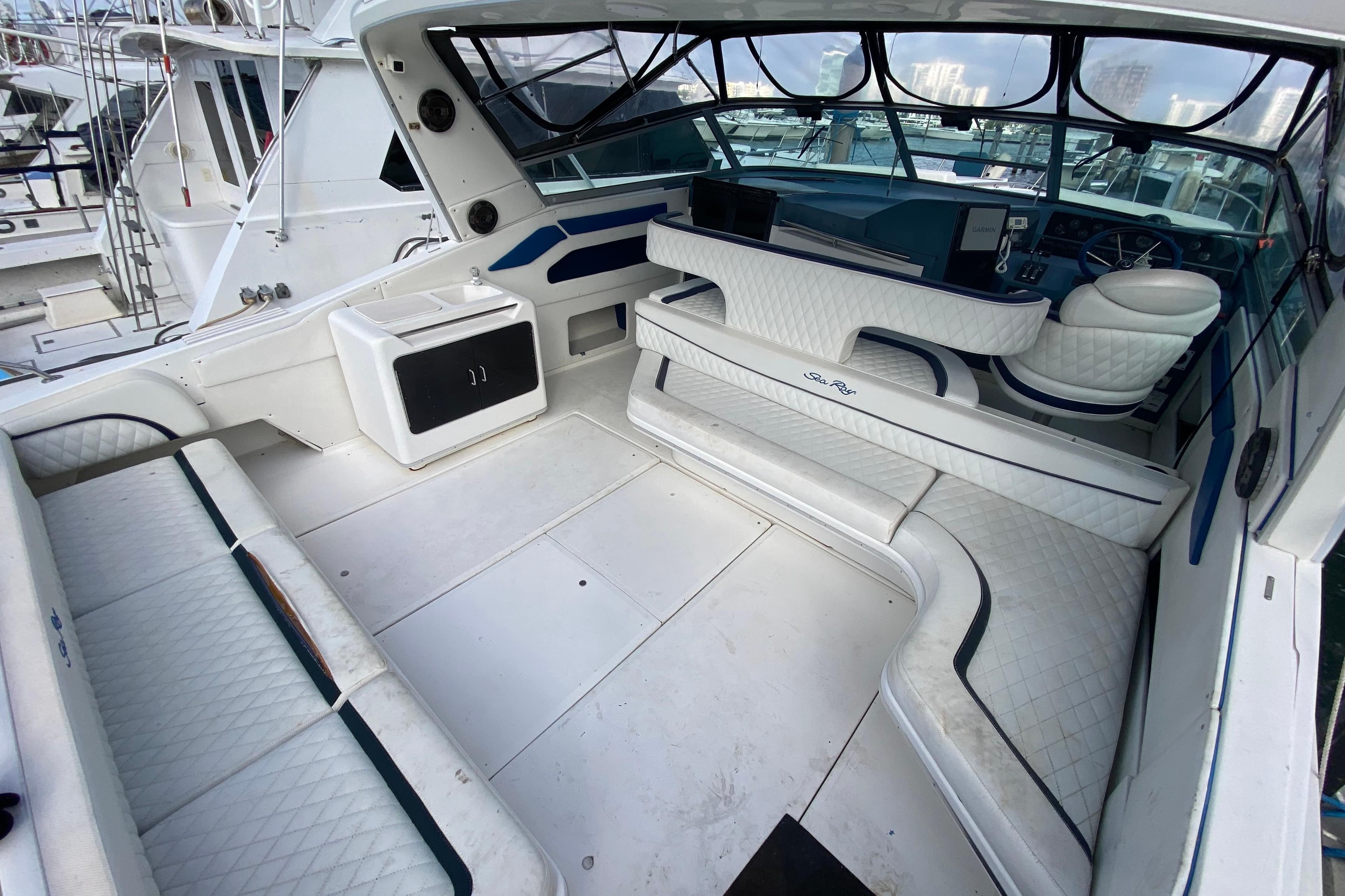 1990 Sea Ray 420 Sundancer interior with white seating and helm, docked at marina.