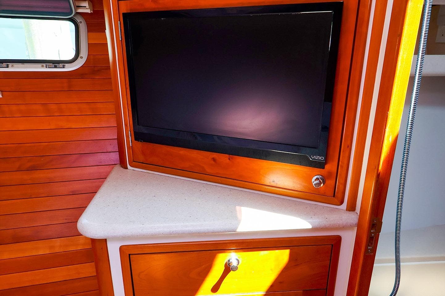 2010 MJM 40z Downeast interior with mounted Vizio TV and wooden cabinetry.