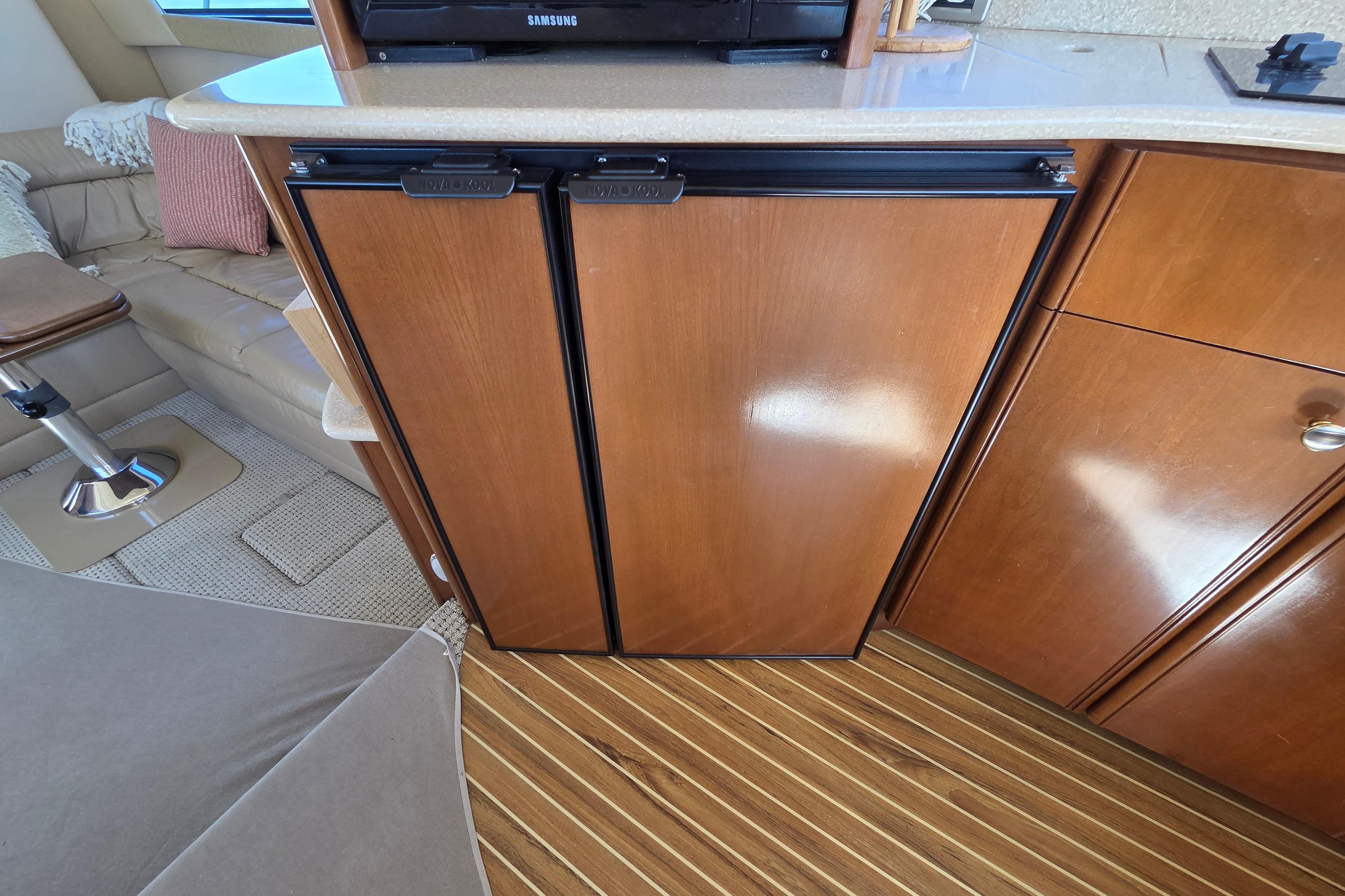 2005 Meridian 411 Sedan interior with wooden cabinetry and compact refrigerator.