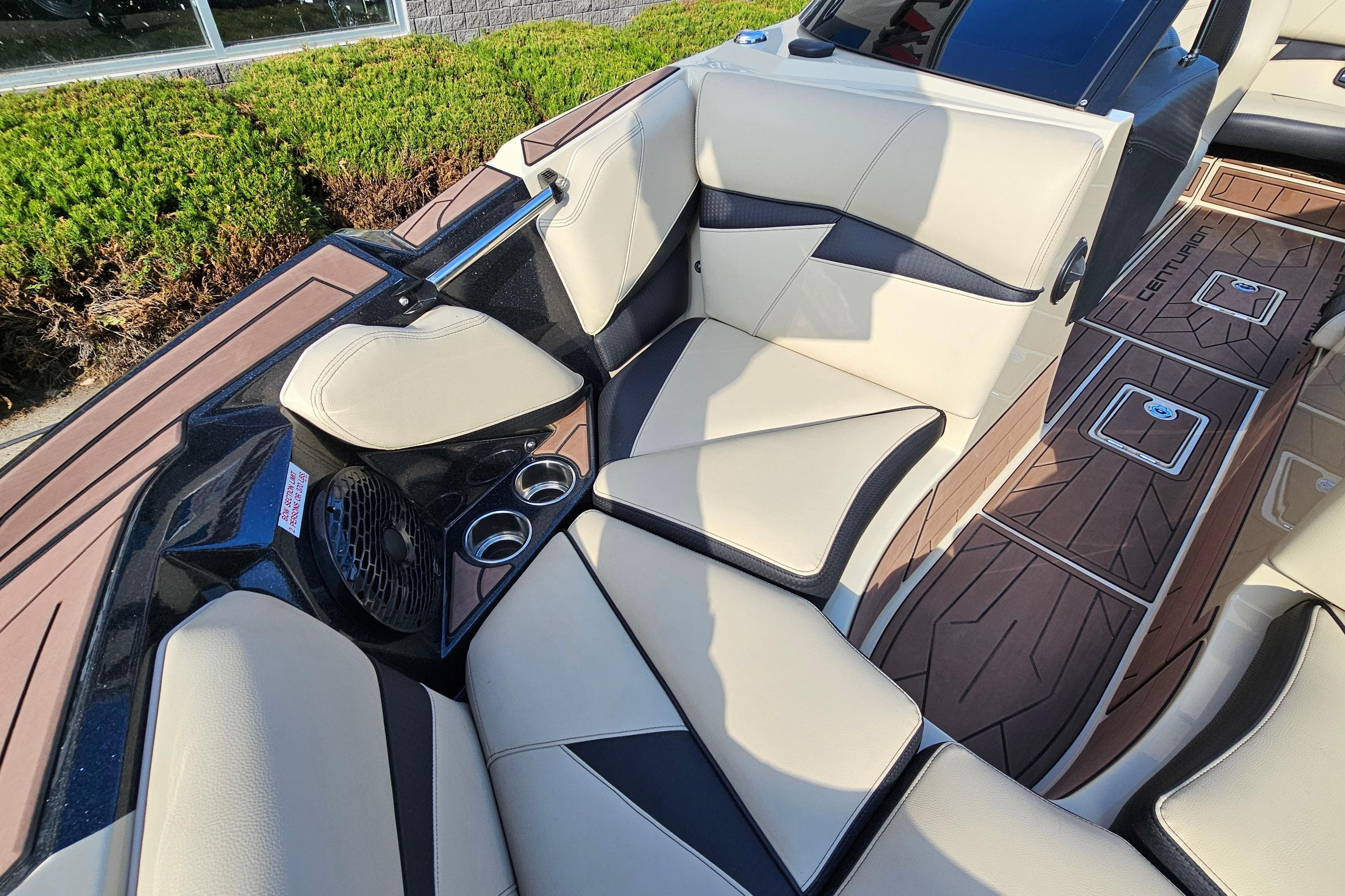 Luxurious interior of 2021 Centurion Fi21 boat with beige seating and cup holders.