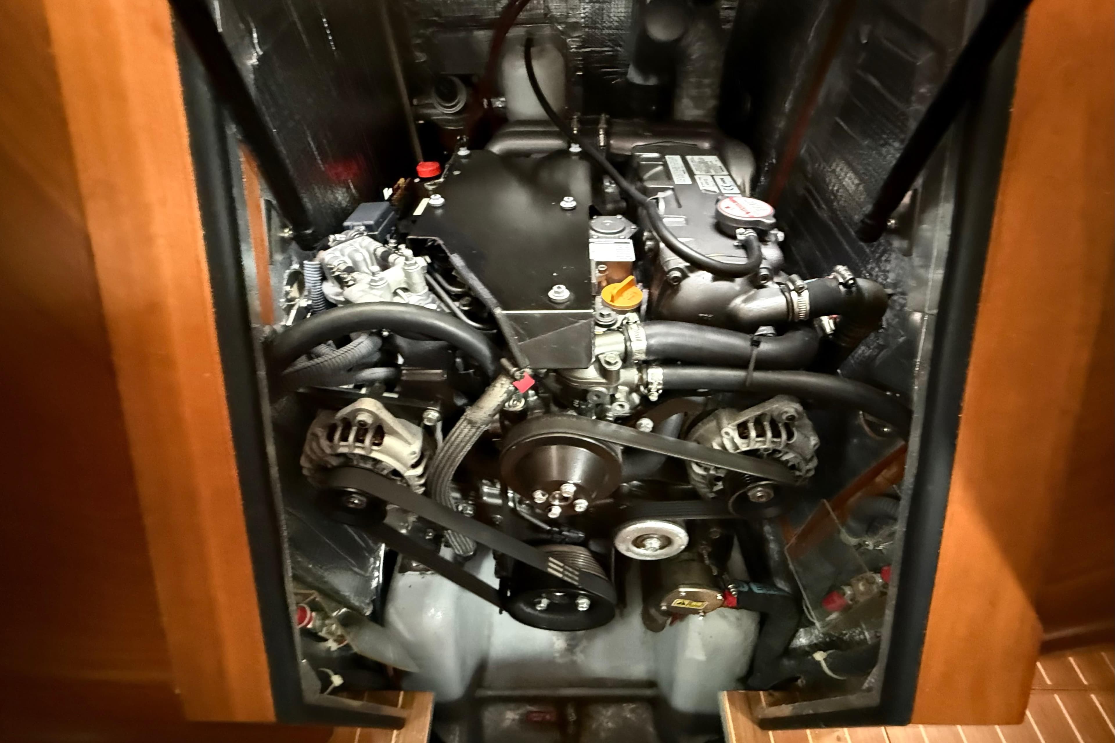 Engine compartment of a 2016 Outbound 46 yacht, showcasing mechanical components and belts.