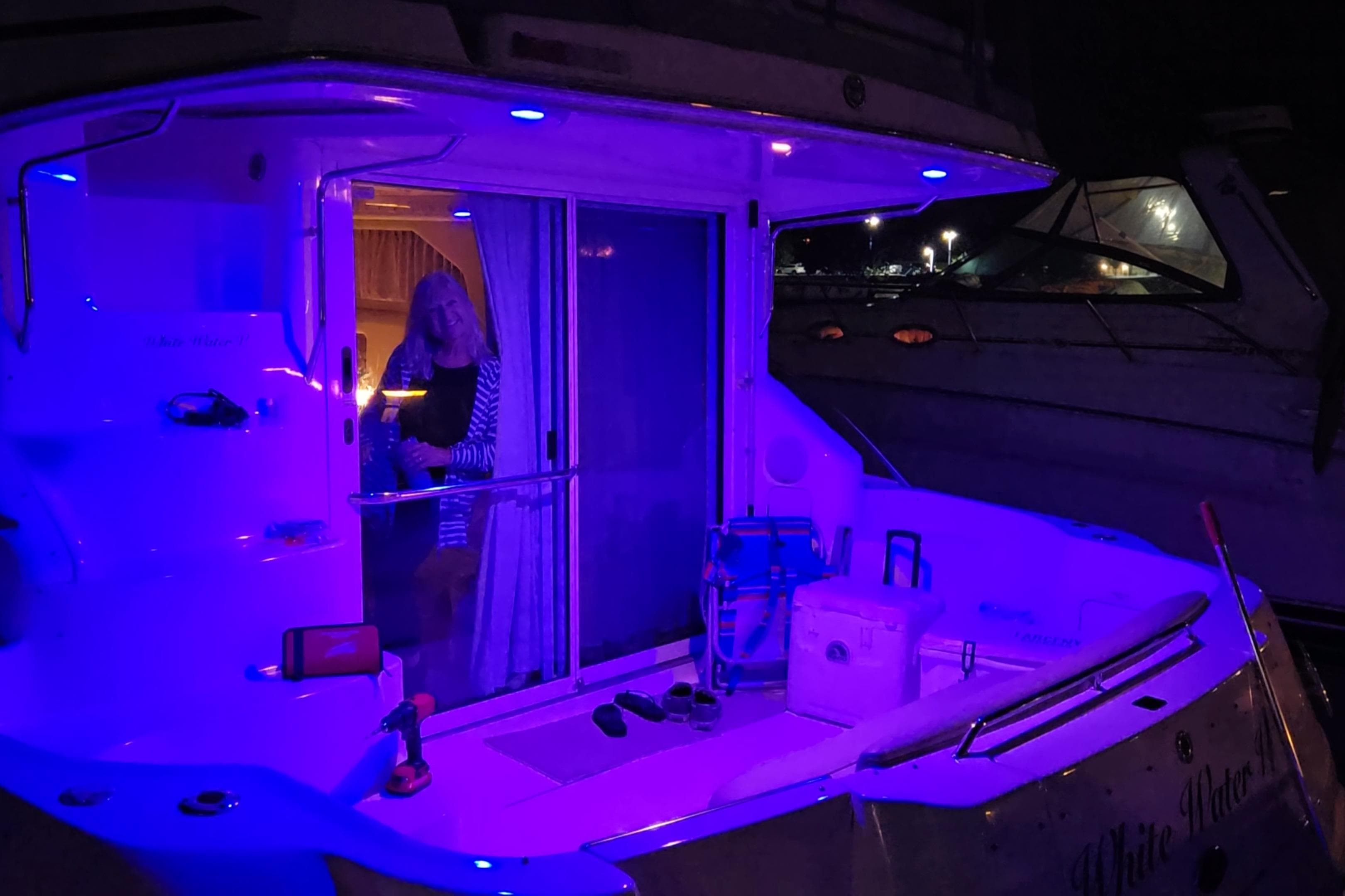 2001 Sea Ray 400 Sedan Bridge yacht illuminated with blue lights at night.