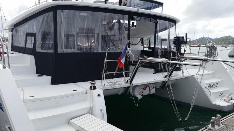 2017 Lagoon 450S catamaran docked at marina, featuring spacious deck and covered seating area.