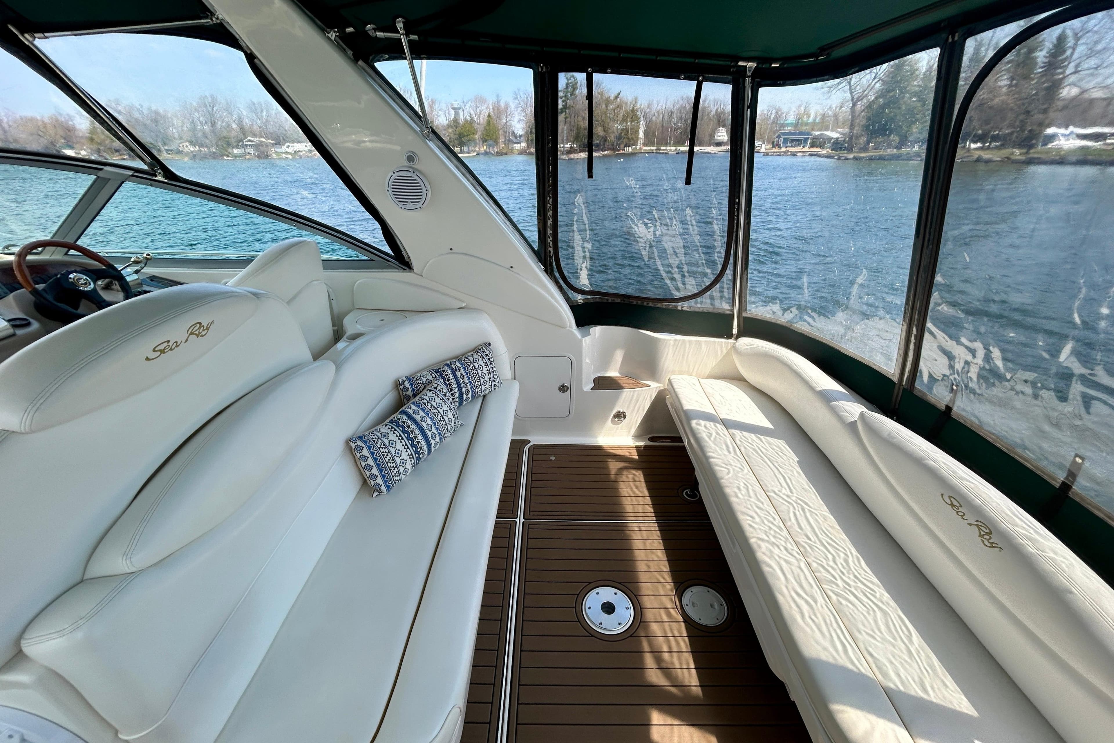 Luxurious 2002 Sea Ray 340 Sundancer interior with plush seating and scenic water view.