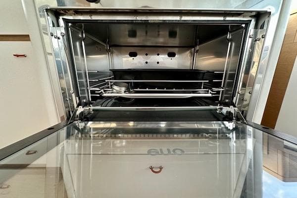 Open oven door of 2025 Excess 14 model, showcasing interior design and features.