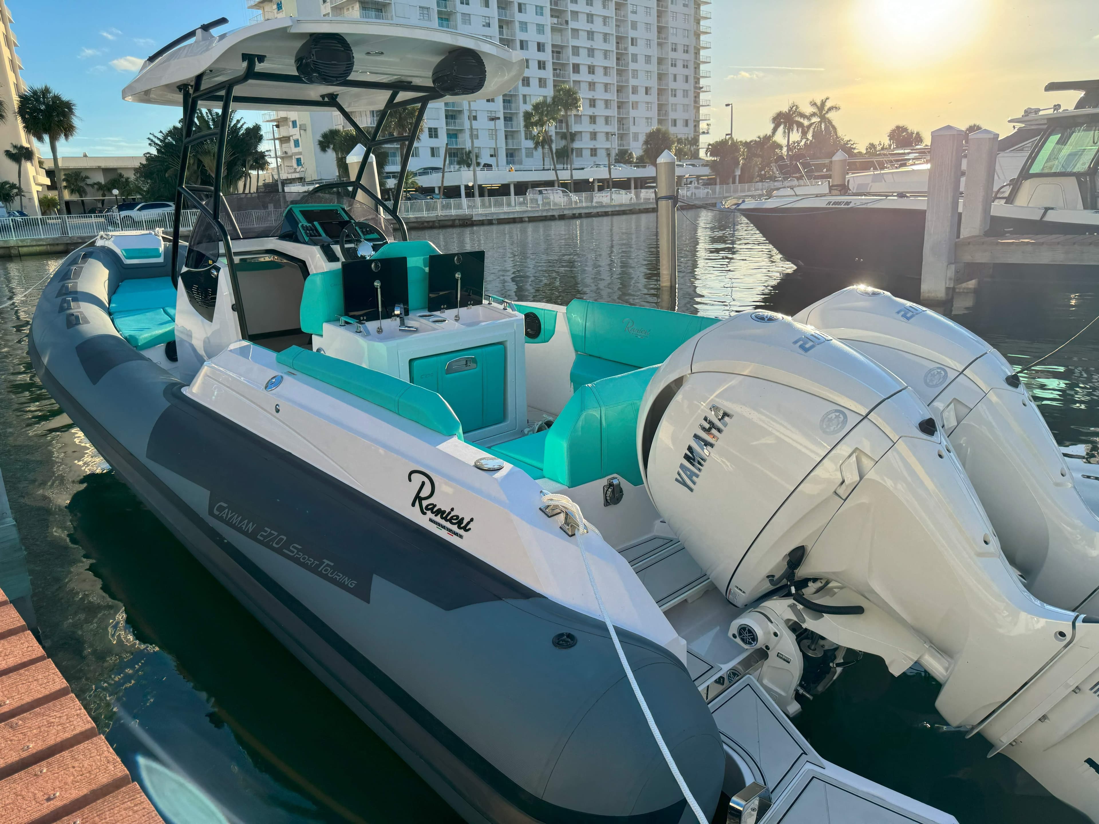 2025 Ranieri CAYMAN 27.0 SPORT TOURING boat docked at marina, sunset view.