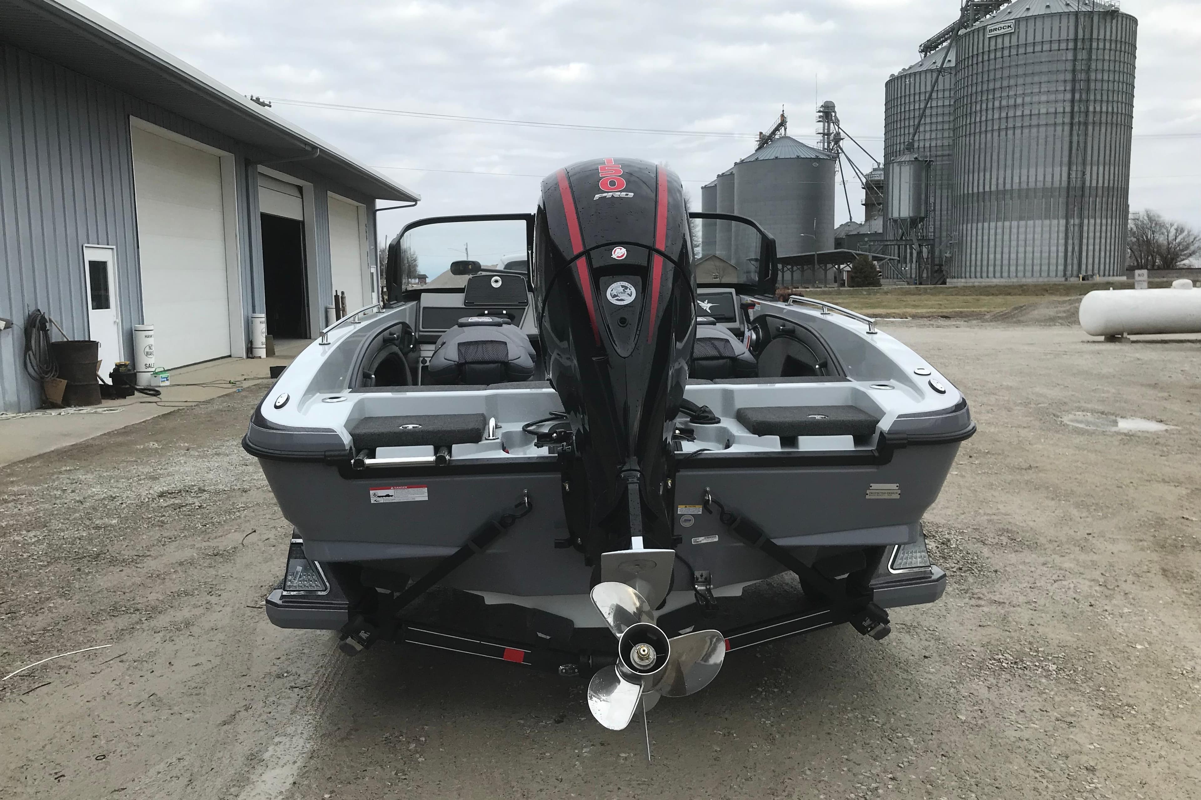 2026 Ranger 1880MS boat with powerful outboard motor, parked near industrial silos.