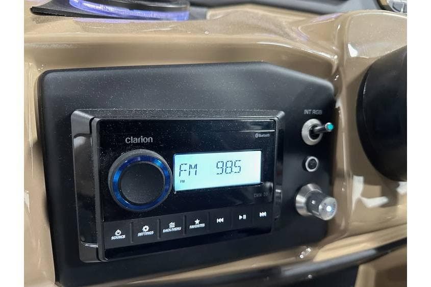 Car dashboard with Clarion radio displaying FM 98.5, Evotti 521QL 2026 model.