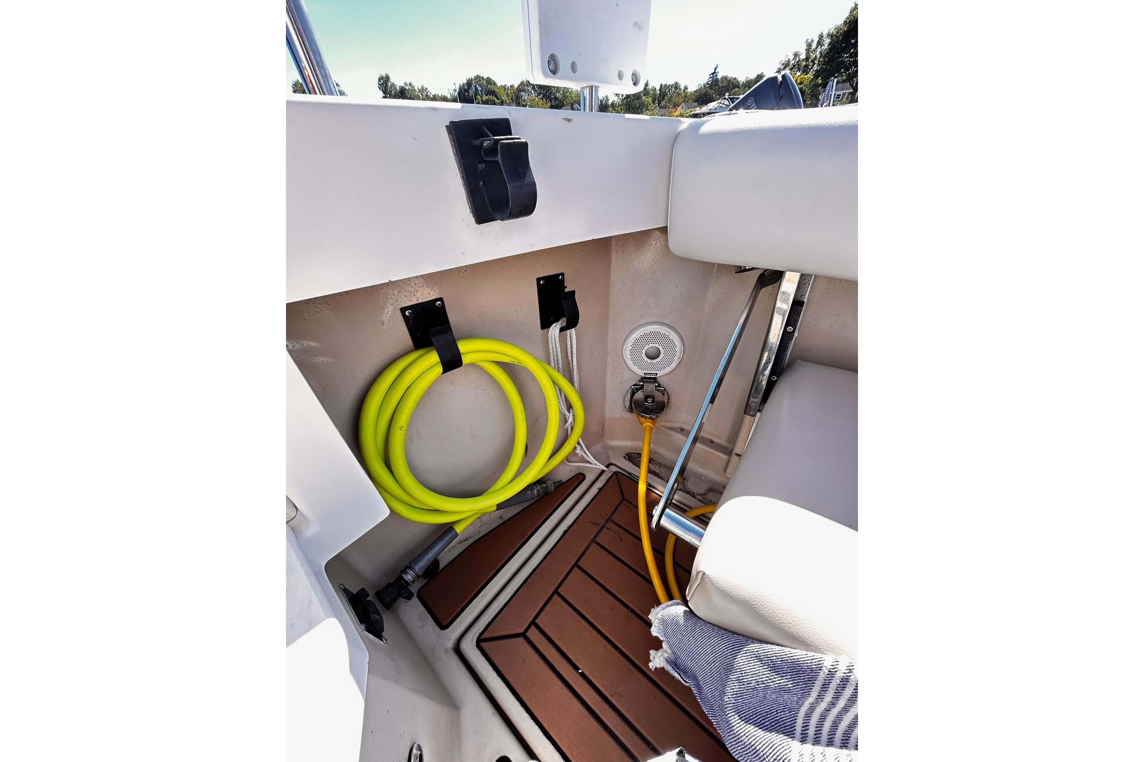 2014 Cutwater C-28 boat interior with coiled yellow hose and teak flooring.