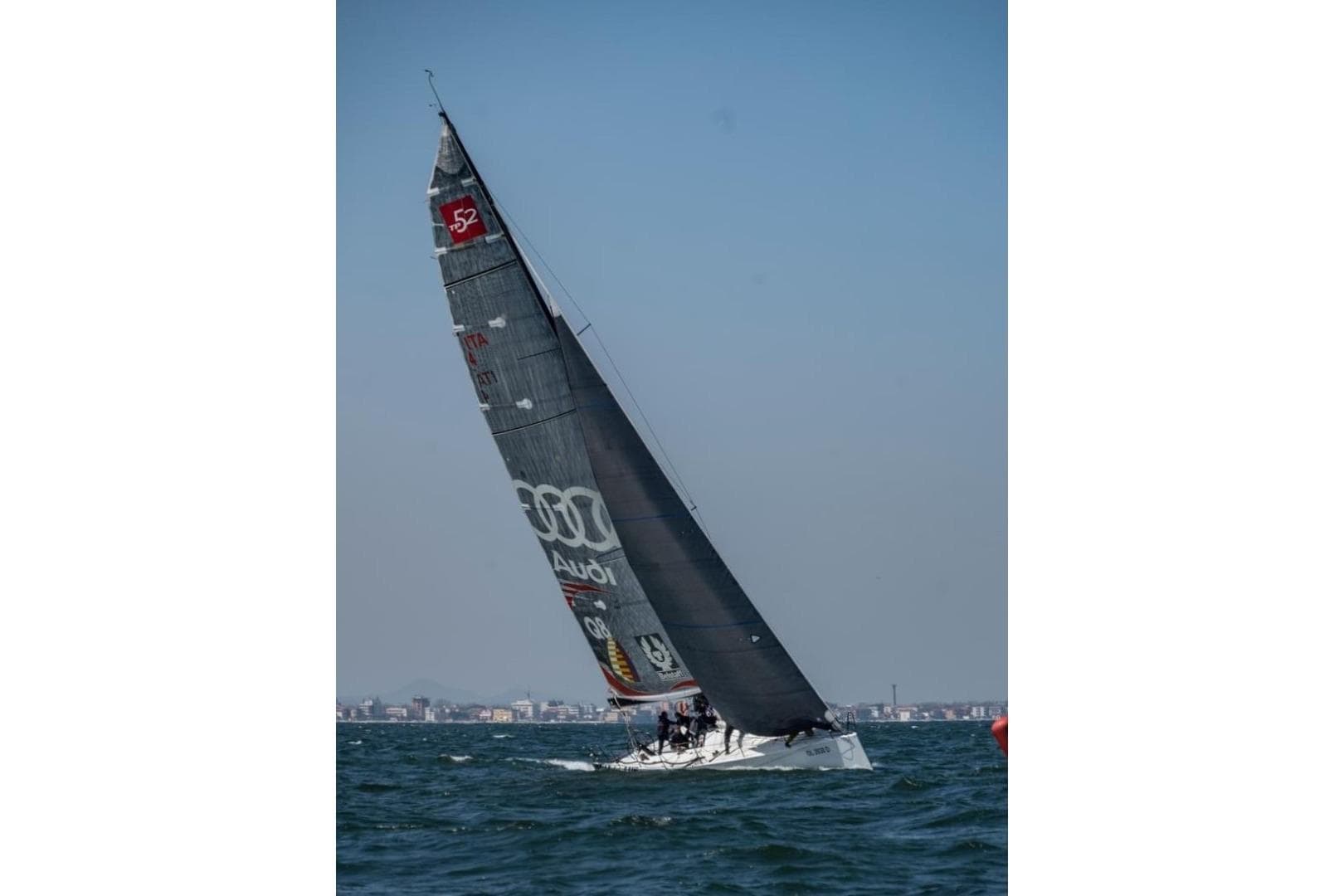 Sailing yacht Botin TP52 (2005) racing on open water under clear skies.