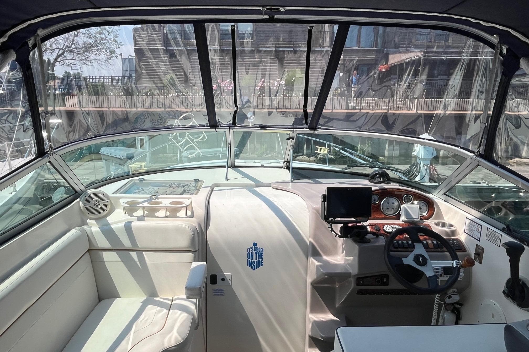 Interior view of 2004 Rinker Fiesta Vee 270 boat cockpit with steering wheel and controls.