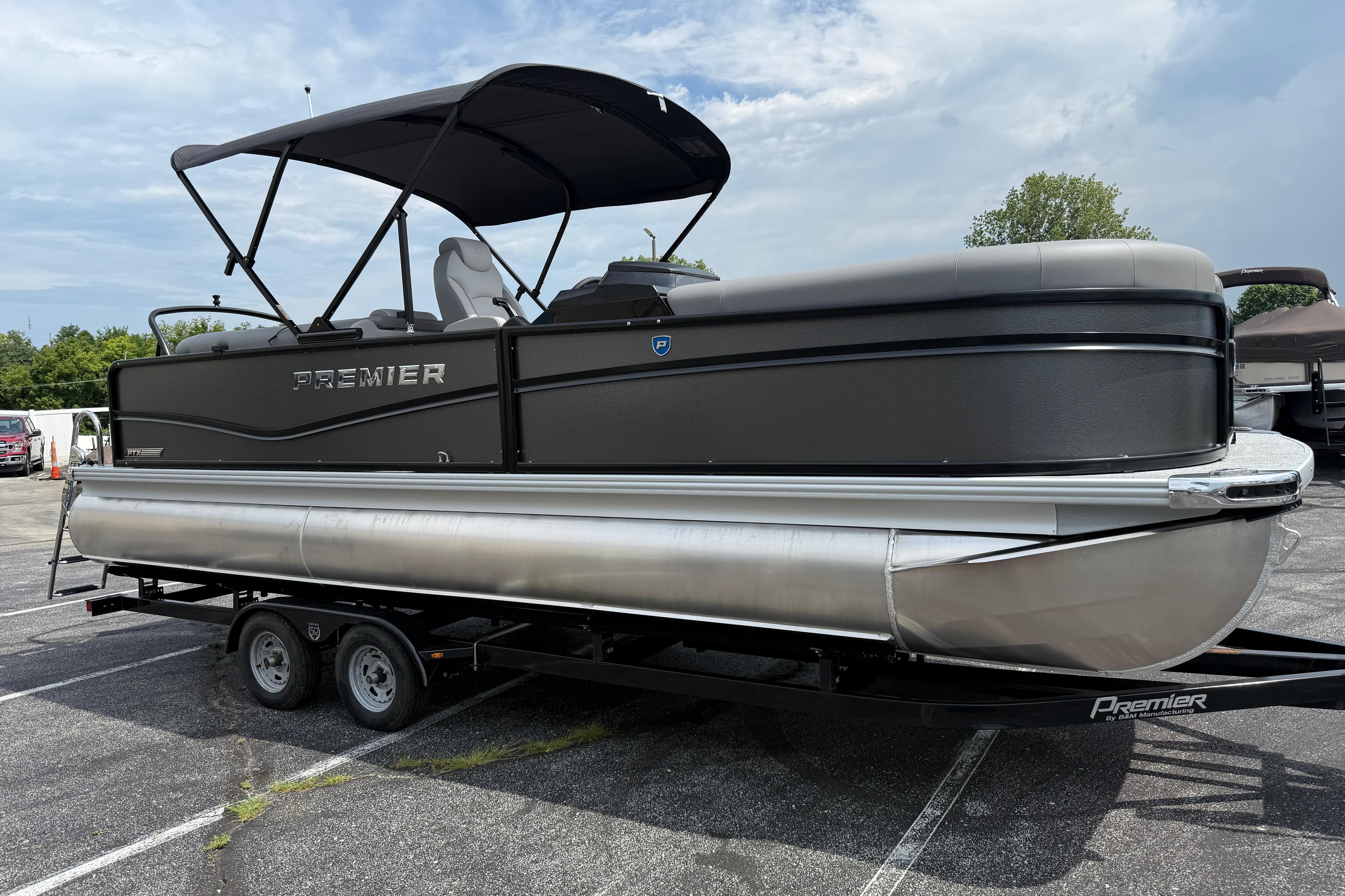 2026 Premier 230 SunSation RF pontoon boat on trailer, parked outdoors.
