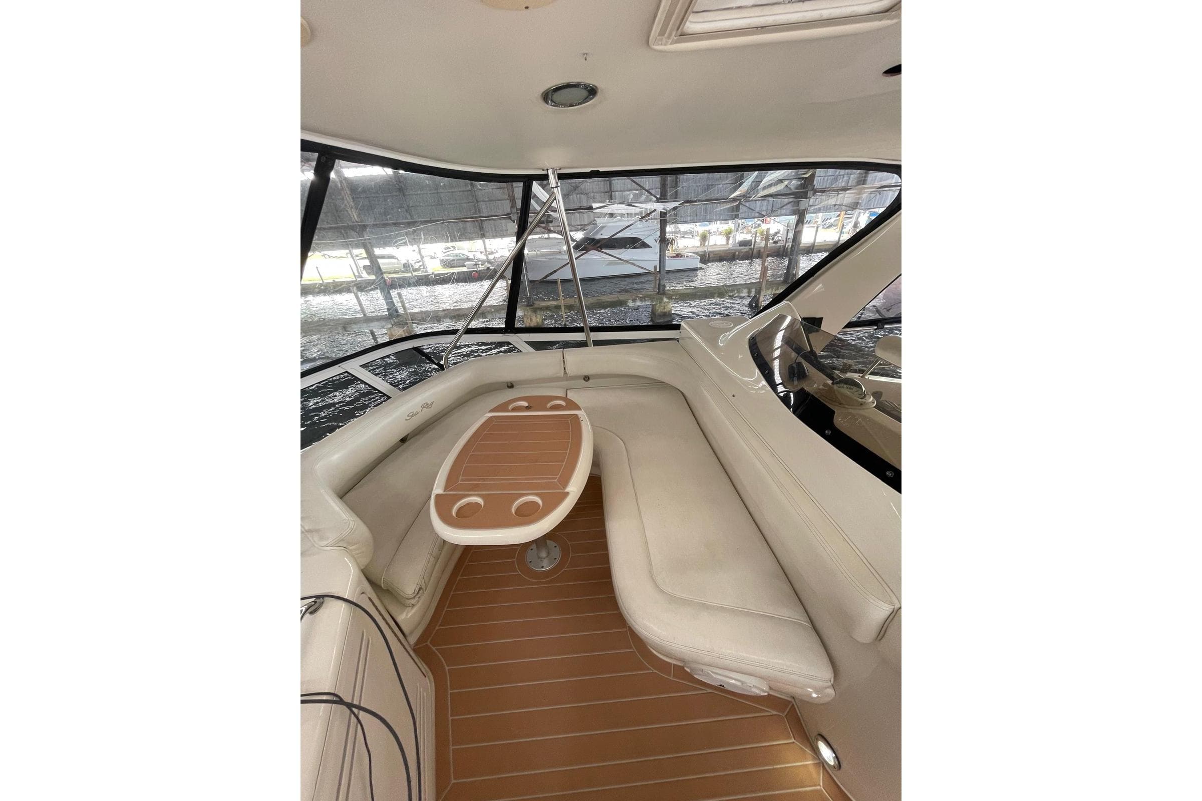 2004 Sea Ray 480 Sedan Bridge interior with seating and table, docked at marina.