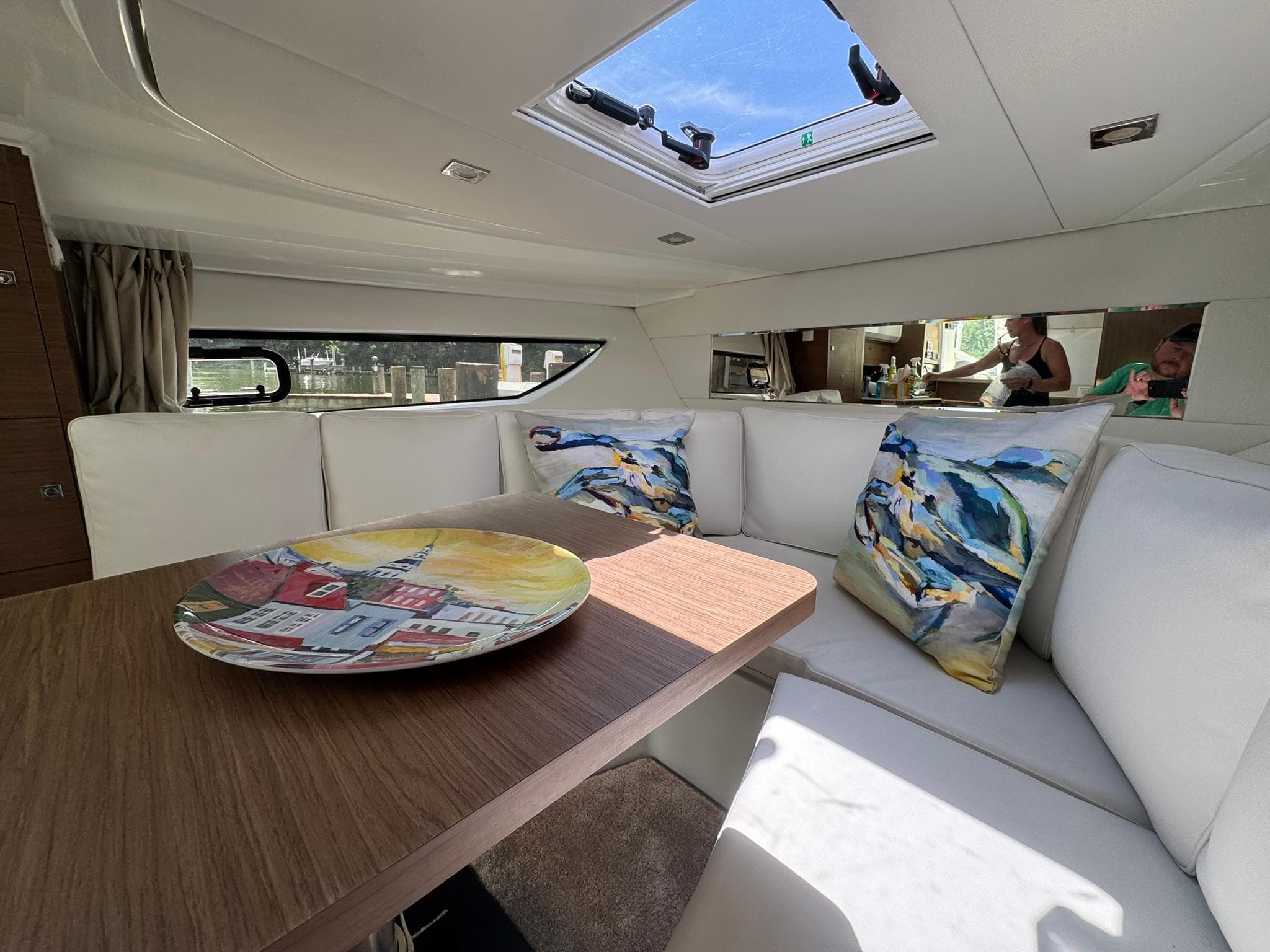 Interior of 2018 Jeanneau Leader 10.5 yacht with cozy seating and decorative pillows.