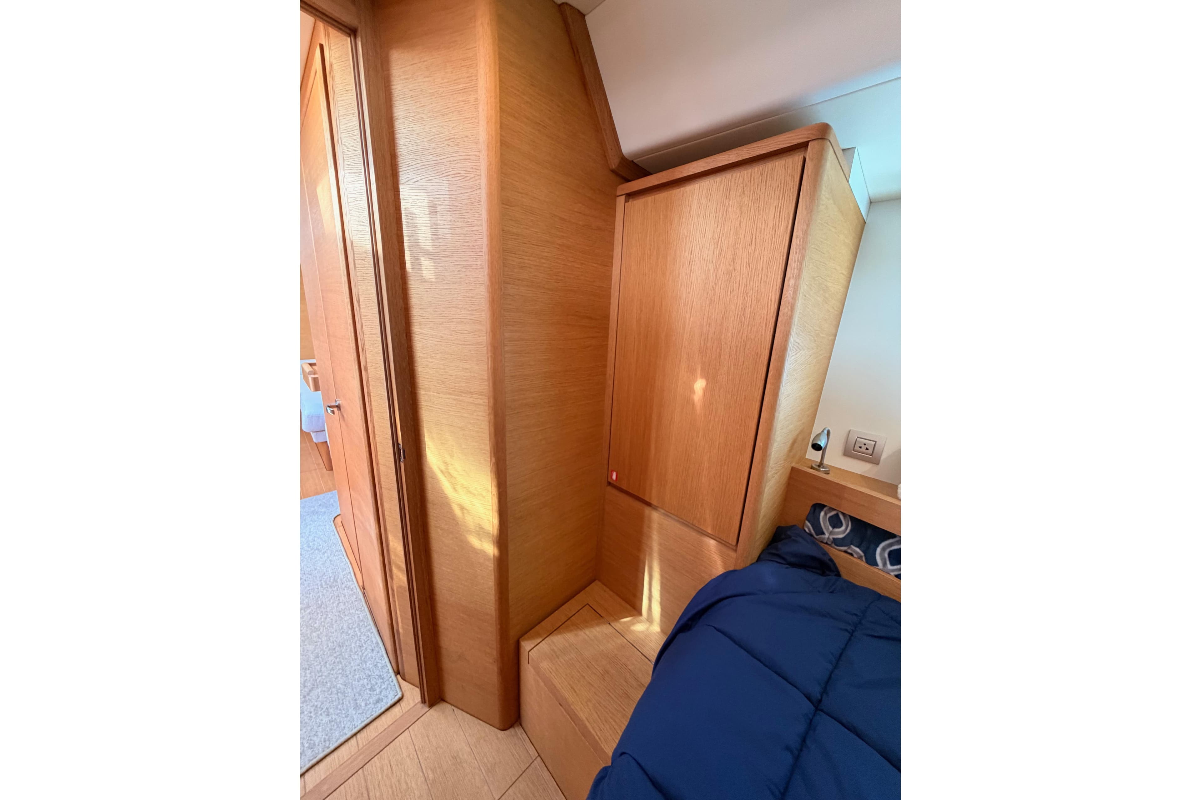 Interior of 2017 Solaris 50 yacht featuring wooden cabinetry and cozy bedding.