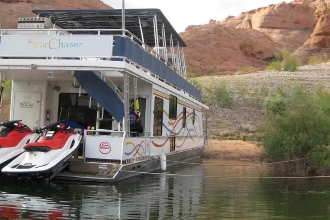 Houseboat "Star Chaser" by Sumerset, 2005 model, docked with jet skis, scenic desert backdrop.