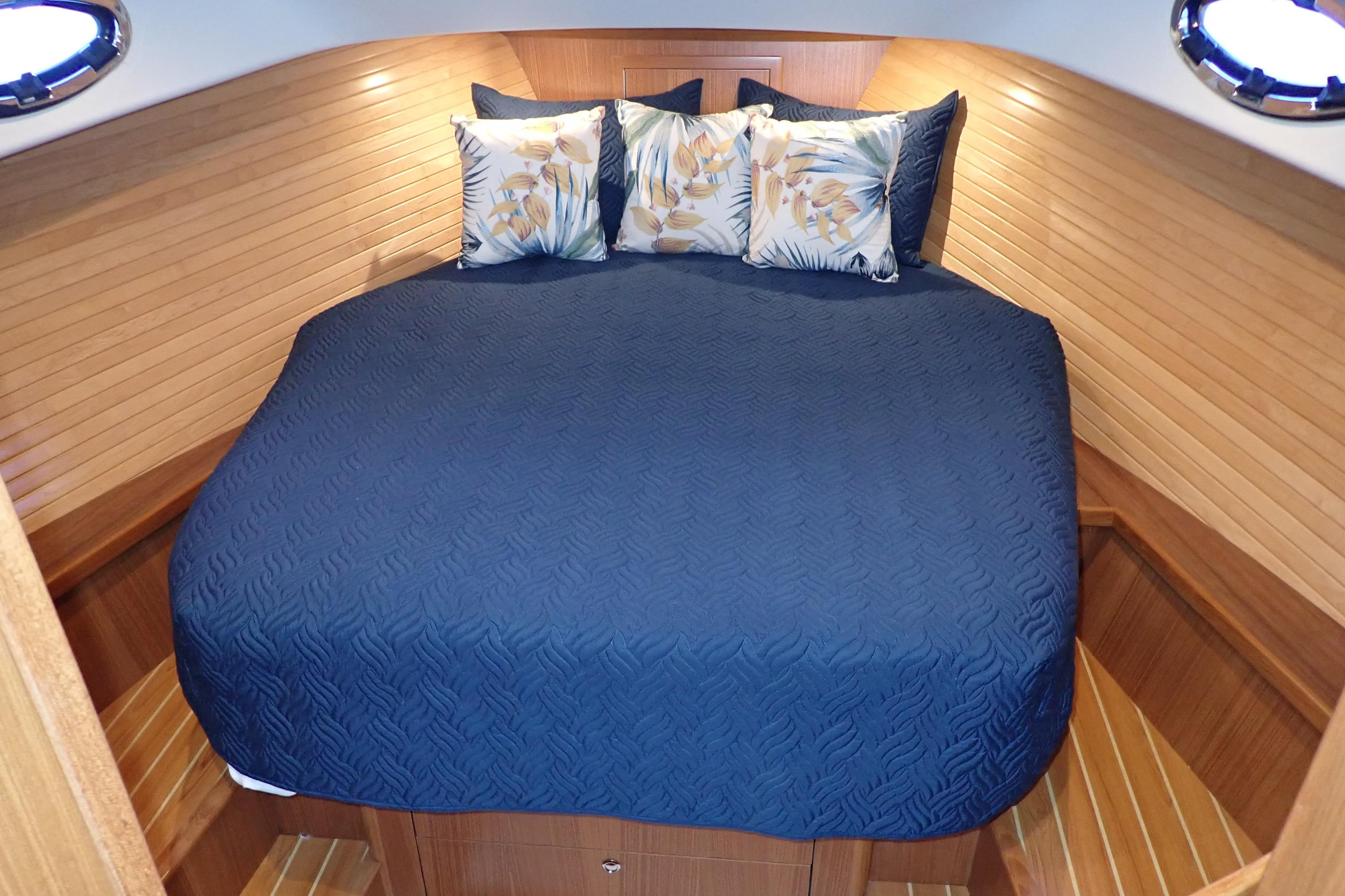 Luxurious cabin interior of 2023 True North 34 Outboard Express with blue bedding.