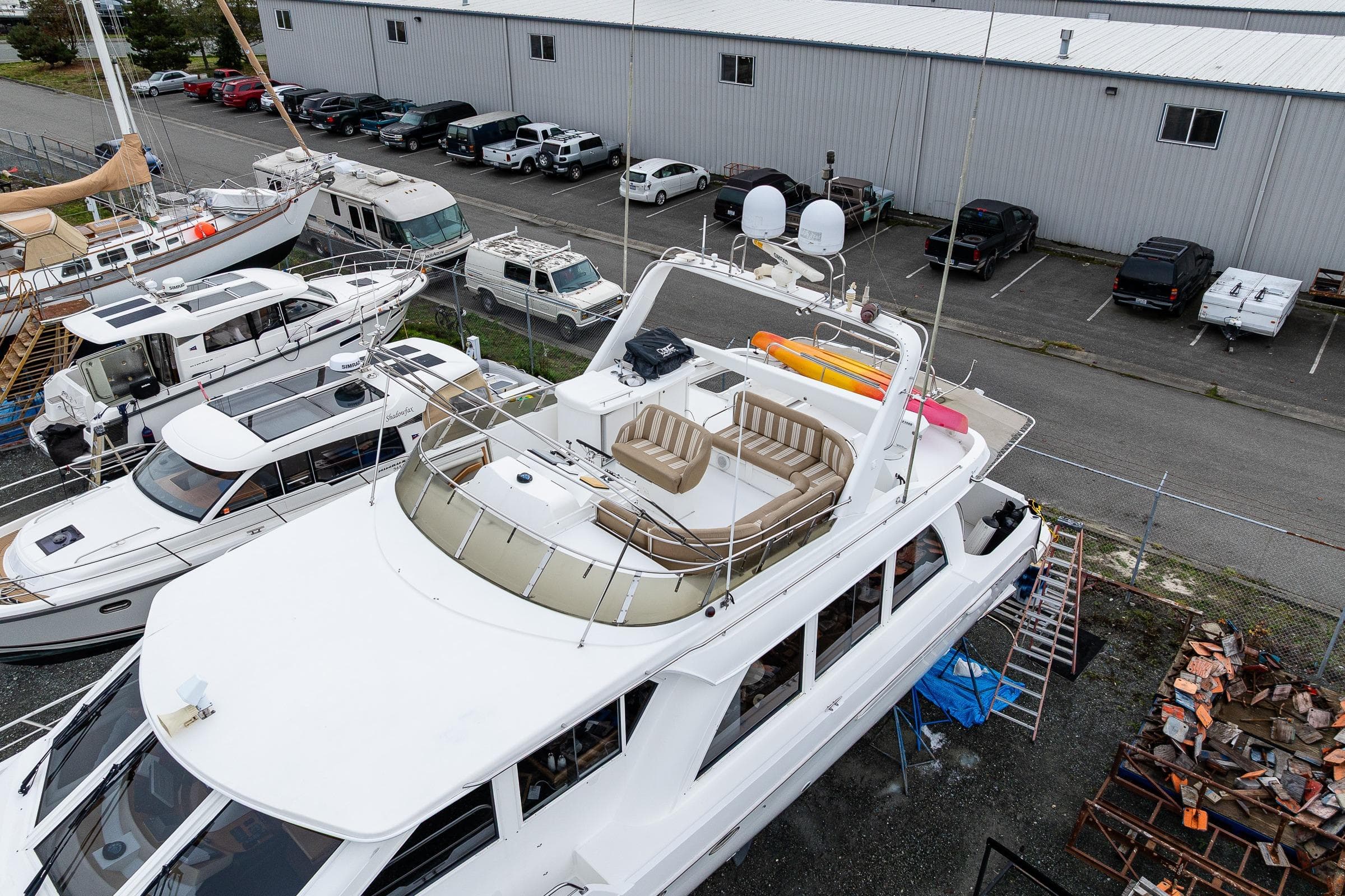 2001 Navigator Pilothouse yacht docked in a marina, surrounded by other boats and vehicles.