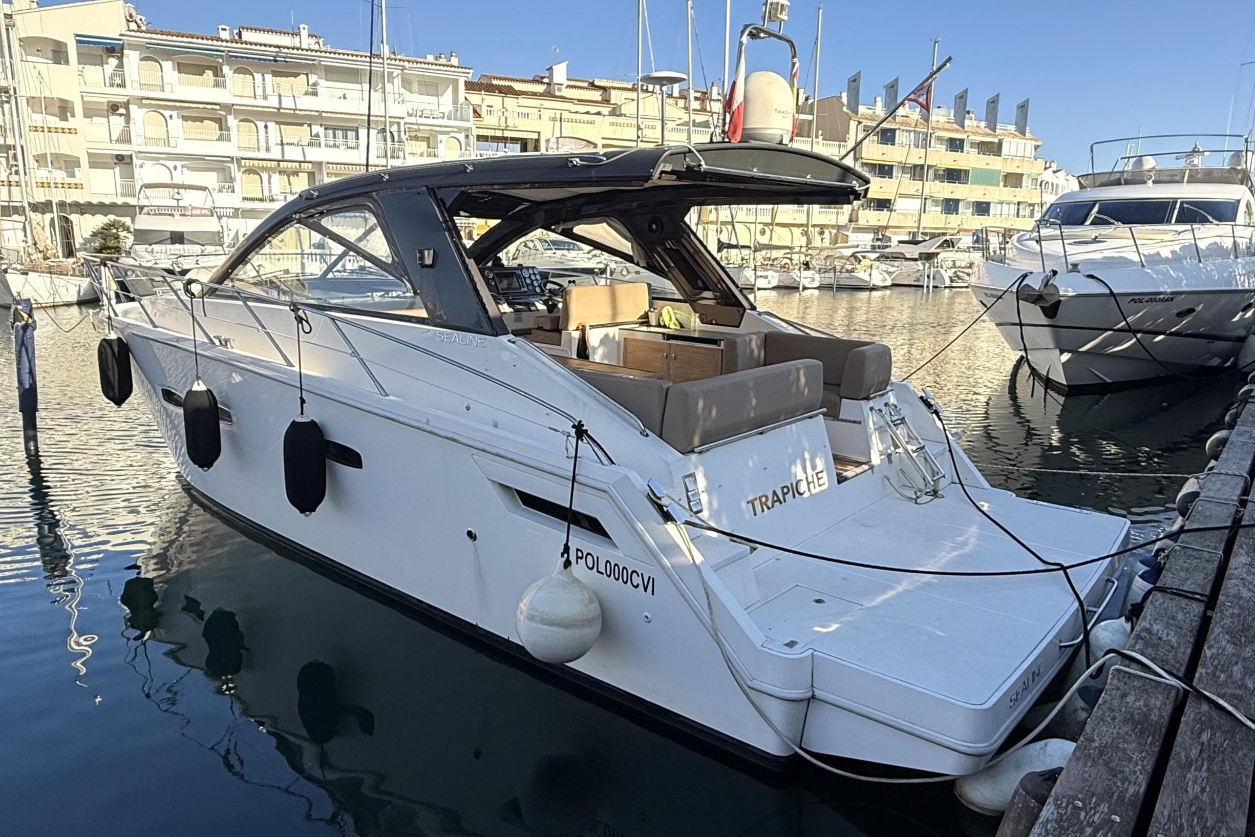 2010 Sealine SC35 yacht docked in a marina, featuring sleek design and spacious deck.