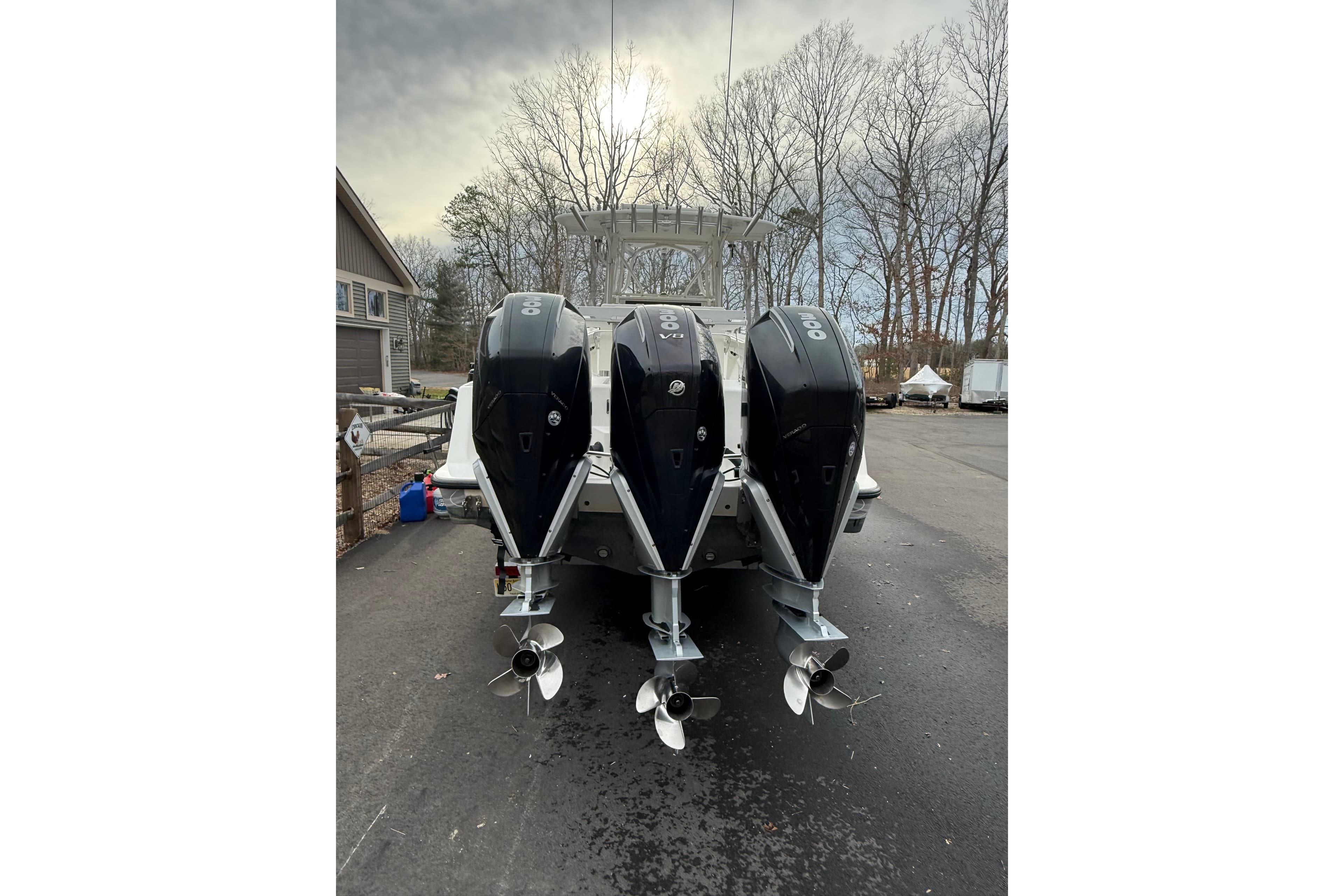 2006 SeaVee 340B boat with triple outboard engines, parked on a driveway.