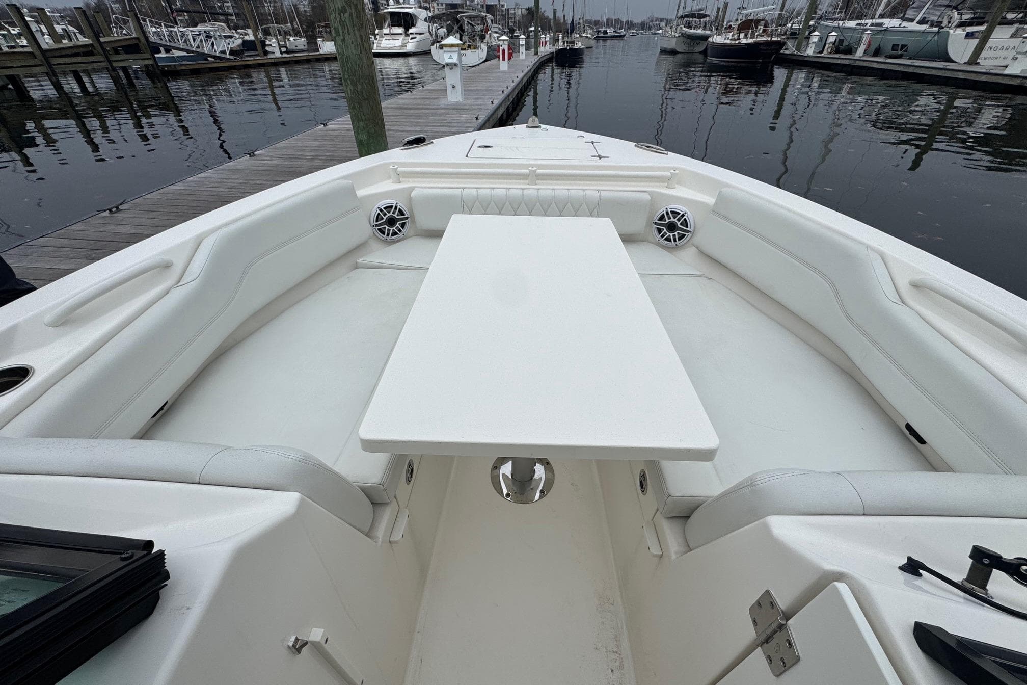 2024 Cobia 240 Dual Console boat interior with seating and table at marina.
