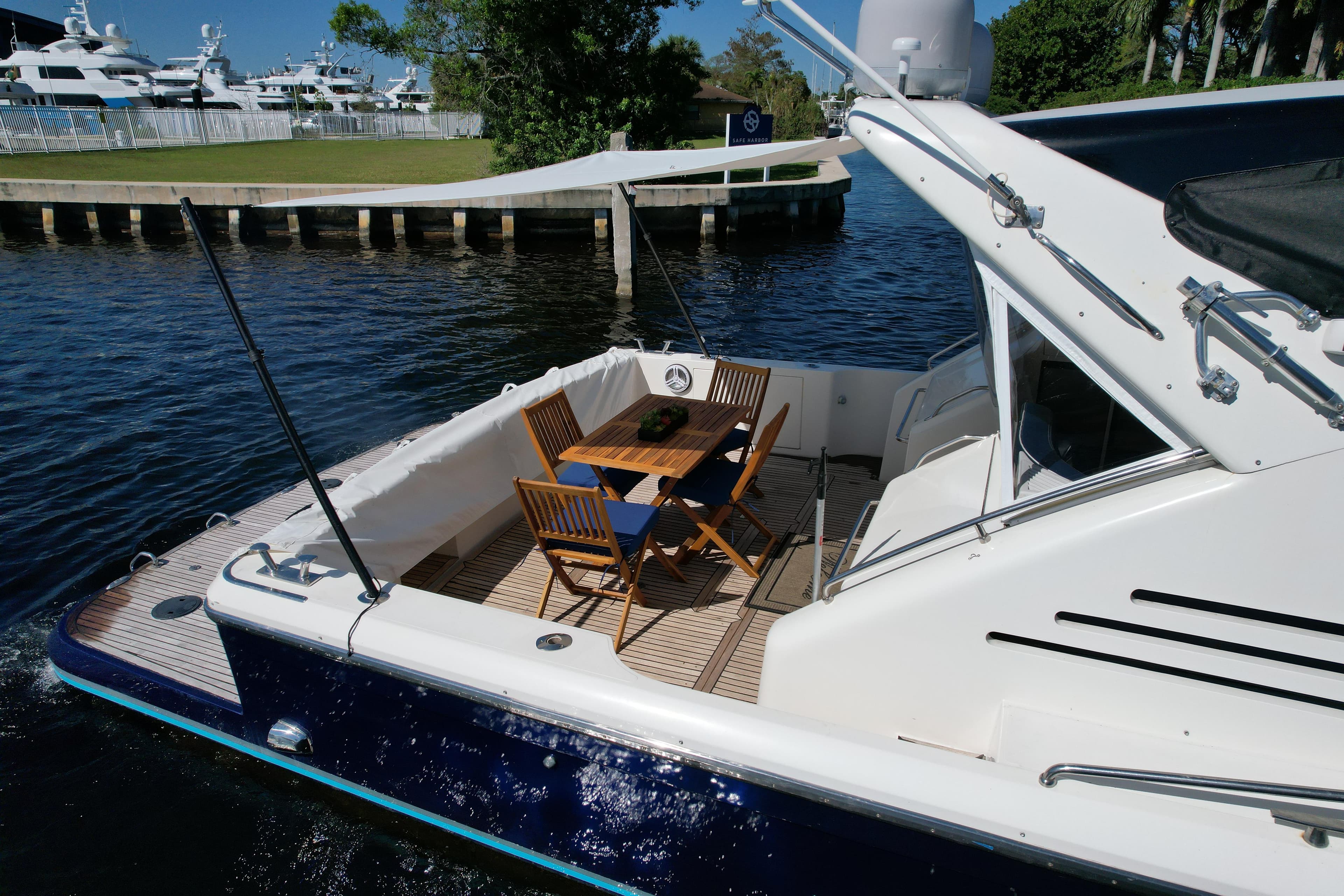 Uniesse 57 Open 1999 yacht with outdoor seating on calm water.