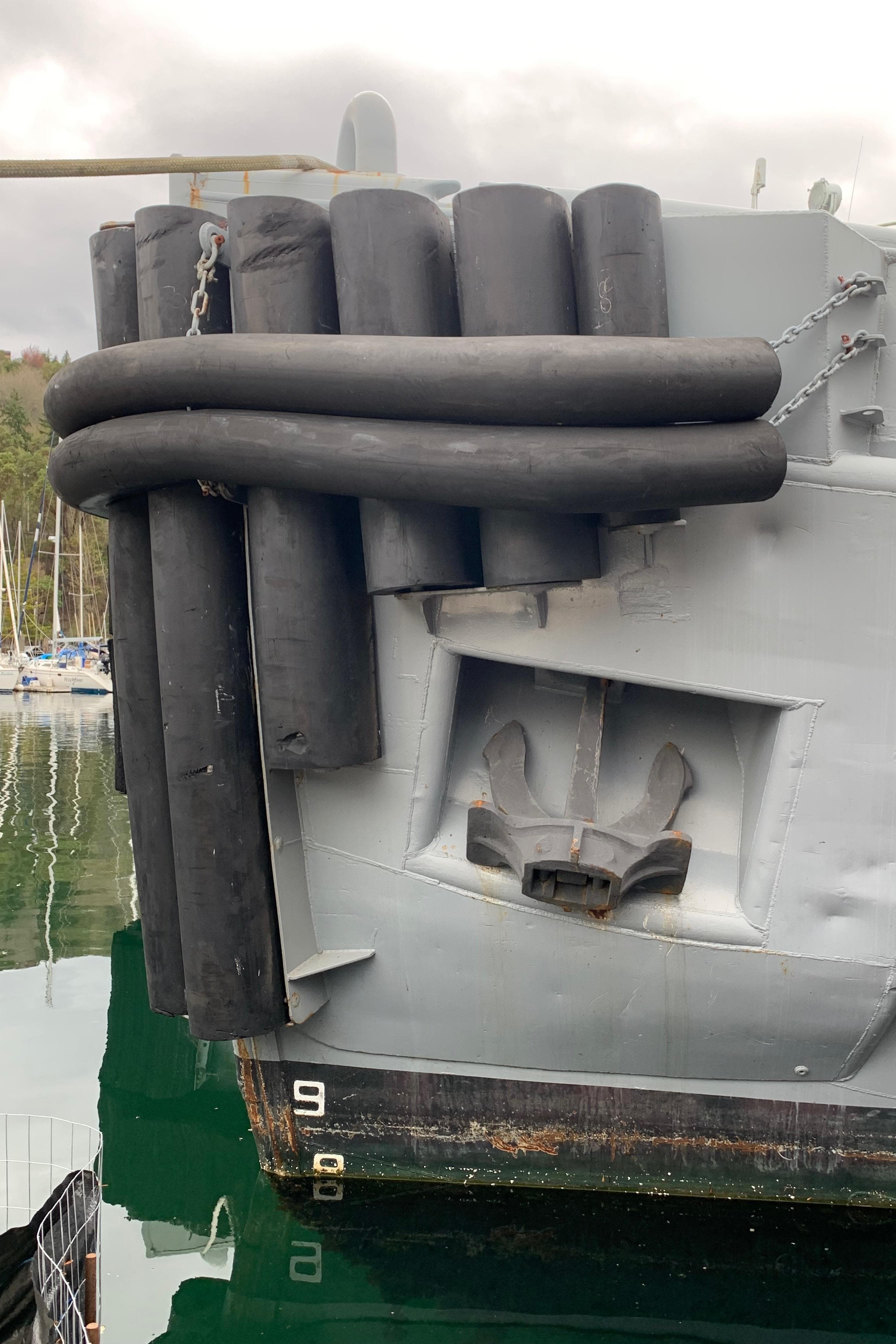 1955 Tugboat L-T 100 Steel Army Tug with rubber fenders in harbor.