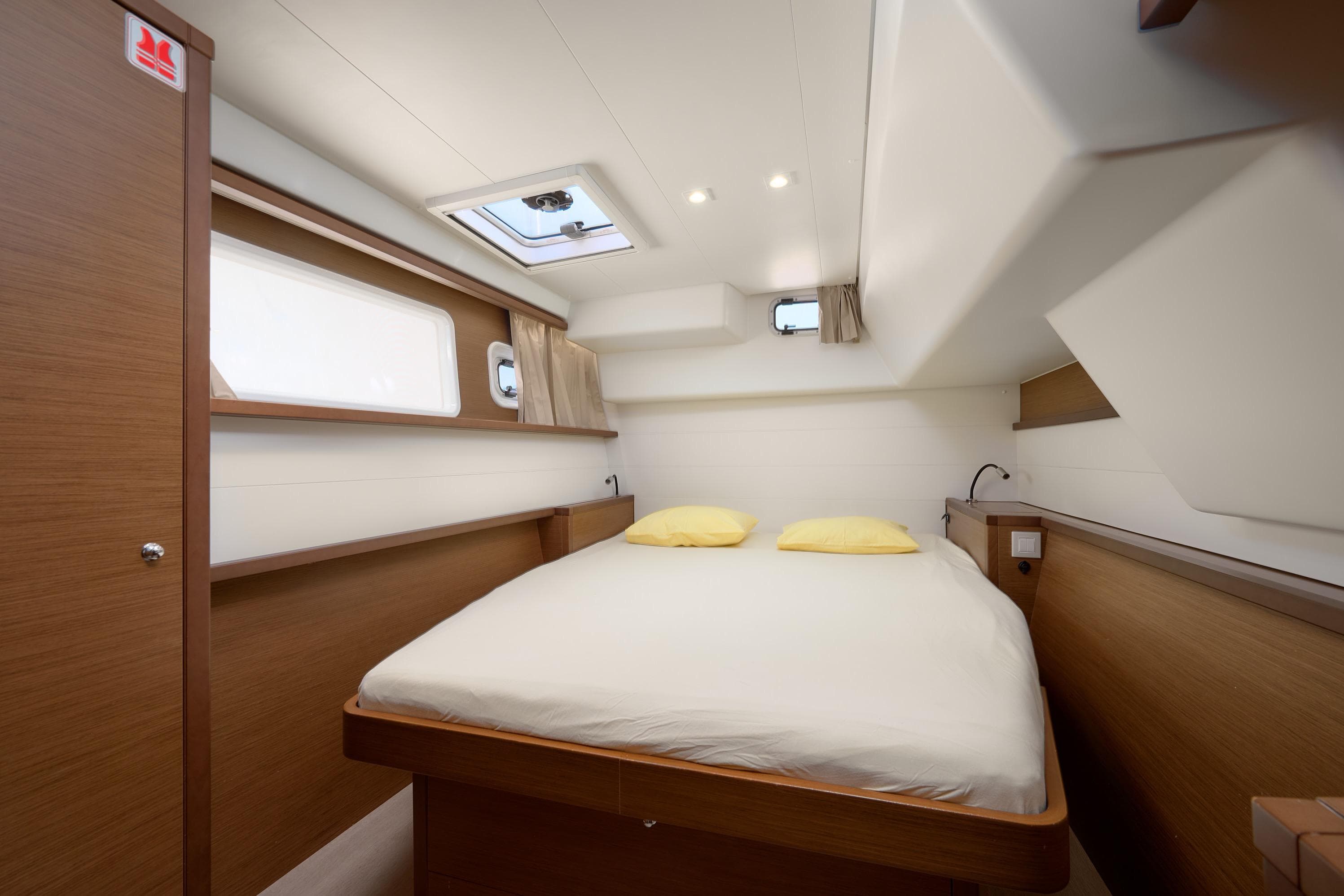 Interior cabin of 2018 Lagoon 450 yacht with cozy bed and wooden accents.