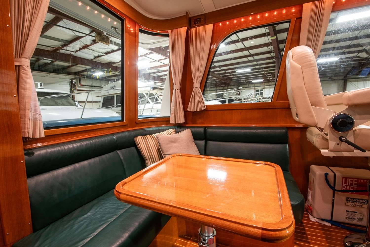 Luxurious 2007 Grand Banks 39 Eastbay SX yacht interior with leather seating and wooden table.