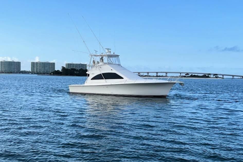 2001 Ocean Yachts 43 Super Sport on calm water with cityscape background.