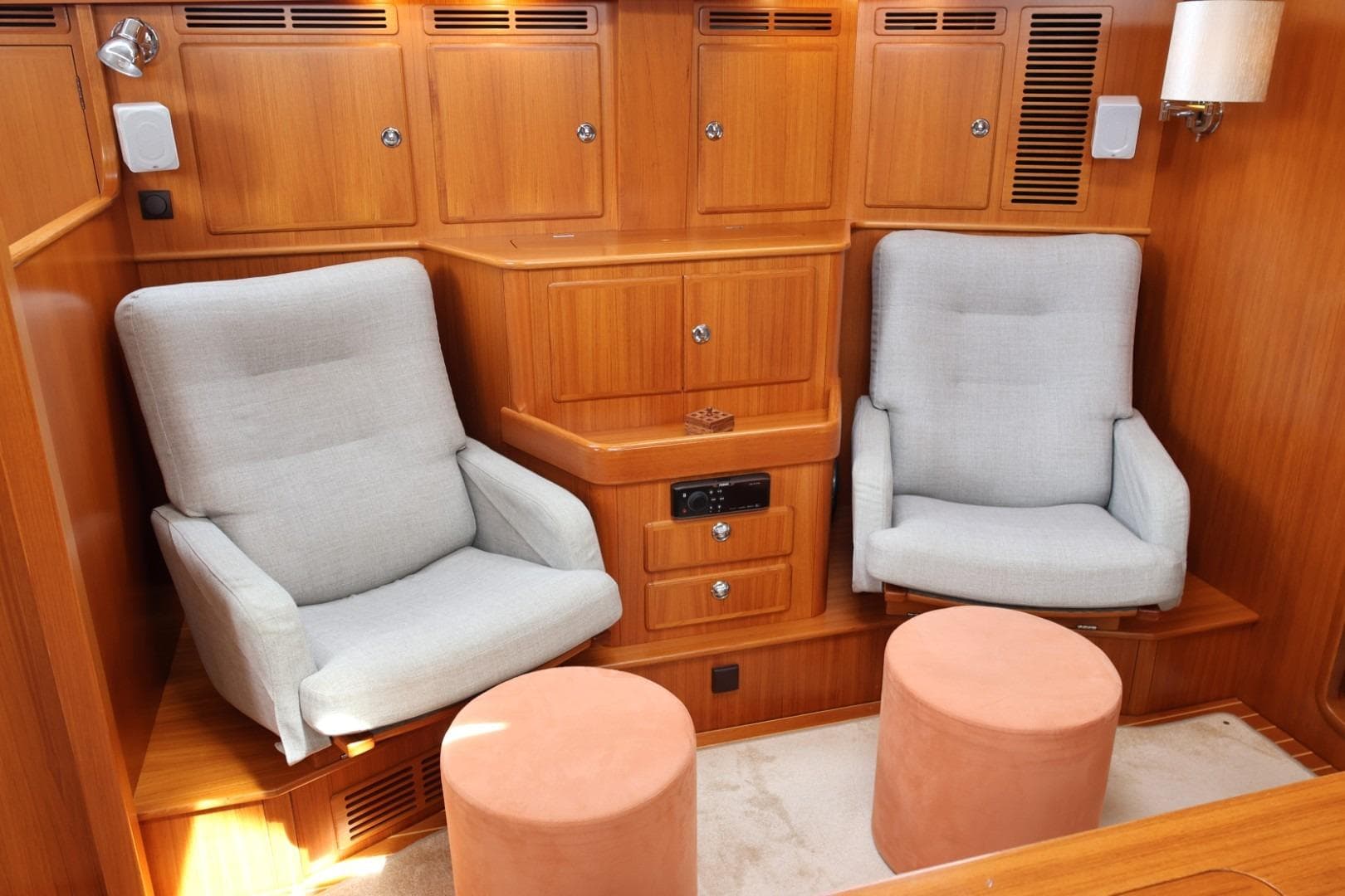 Cozy interior of 2009 Hallberg-Rassy 54 yacht with comfortable seating and wooden cabinetry.
