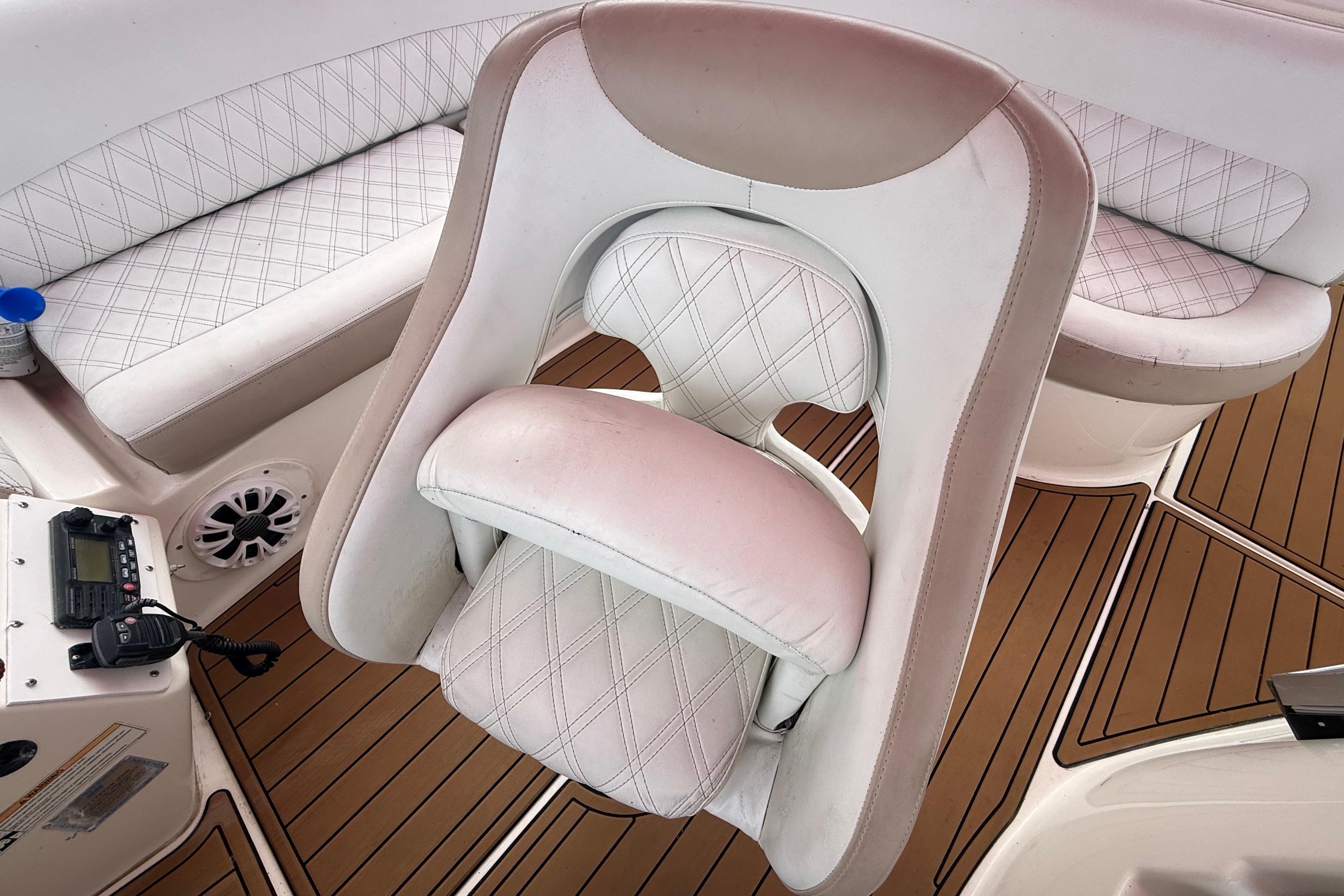 Captain's chair on 2007 Meridian 459 Motoryacht with white upholstery and teak flooring.