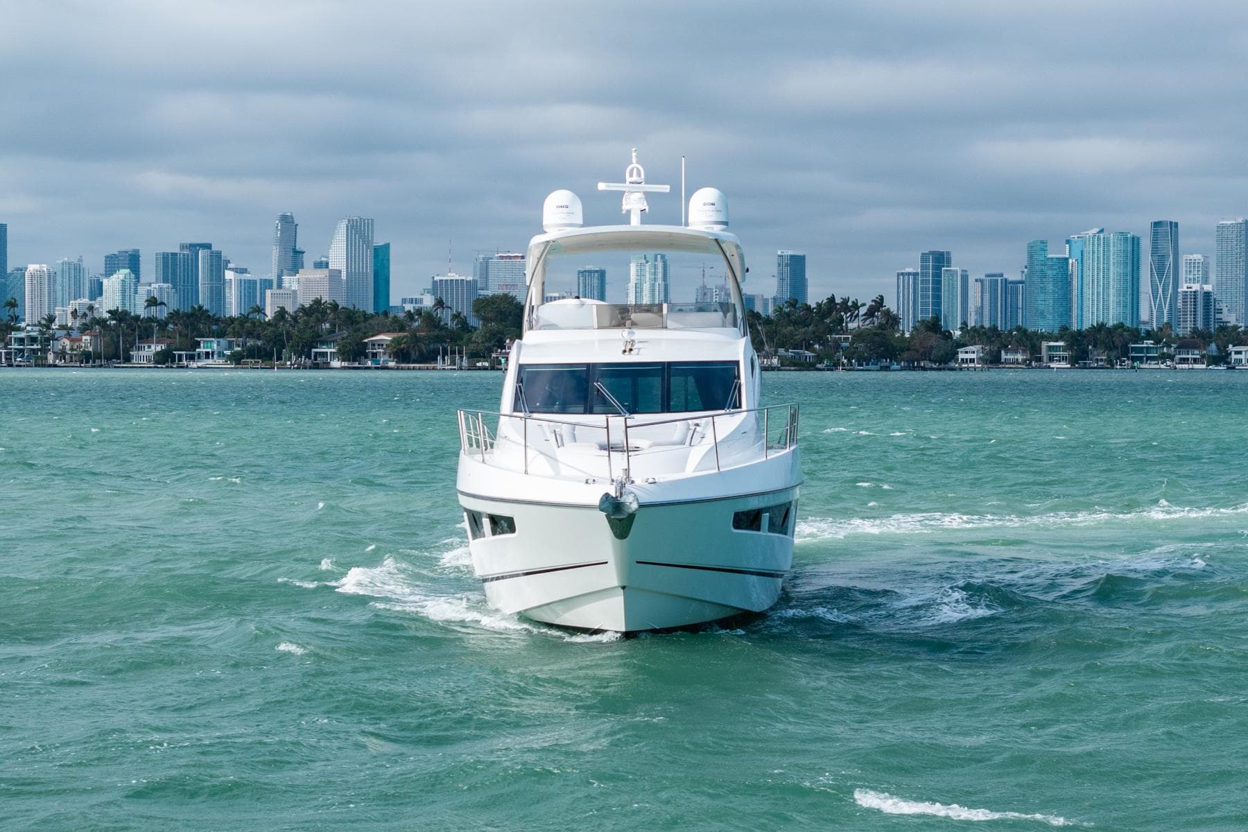 2016 Sunseeker Manhattan 65 yacht cruising with city skyline in the background.
