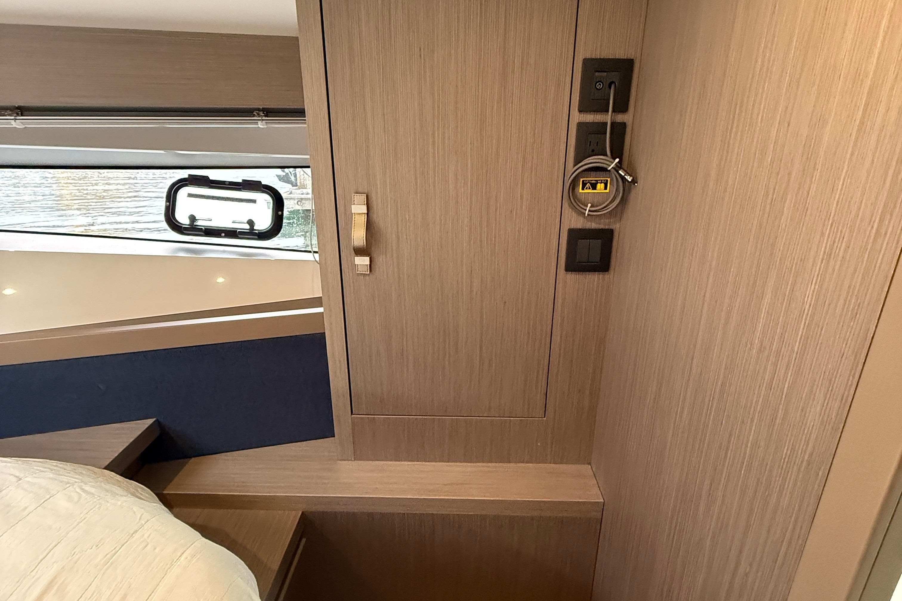 Interior cabin of 2022 Beneteau Gran Turismo 41 yacht with wood paneling and window.