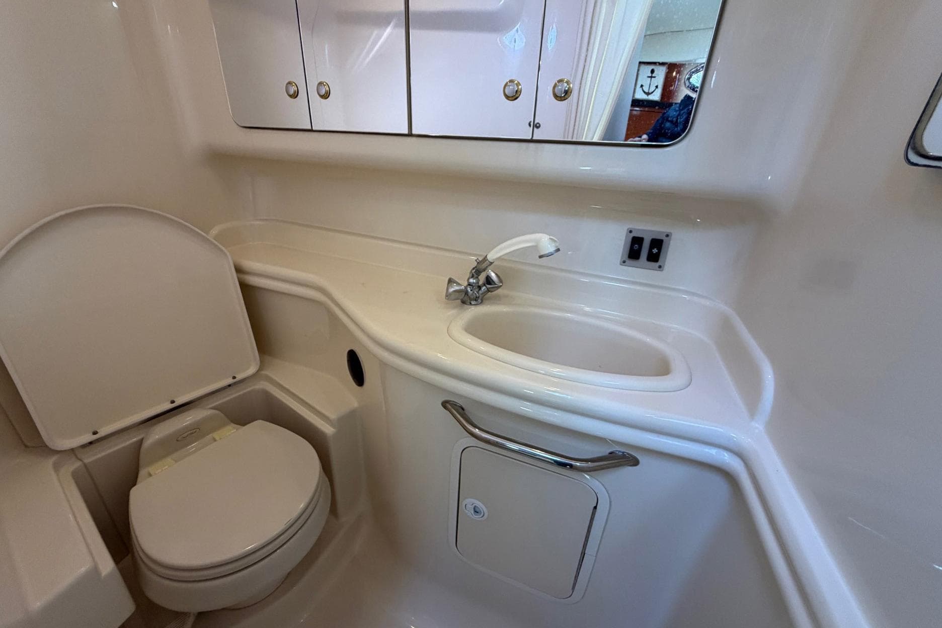 2004 Sea Ray 340 Sundancer bathroom with sink, toilet, and storage cabinets.