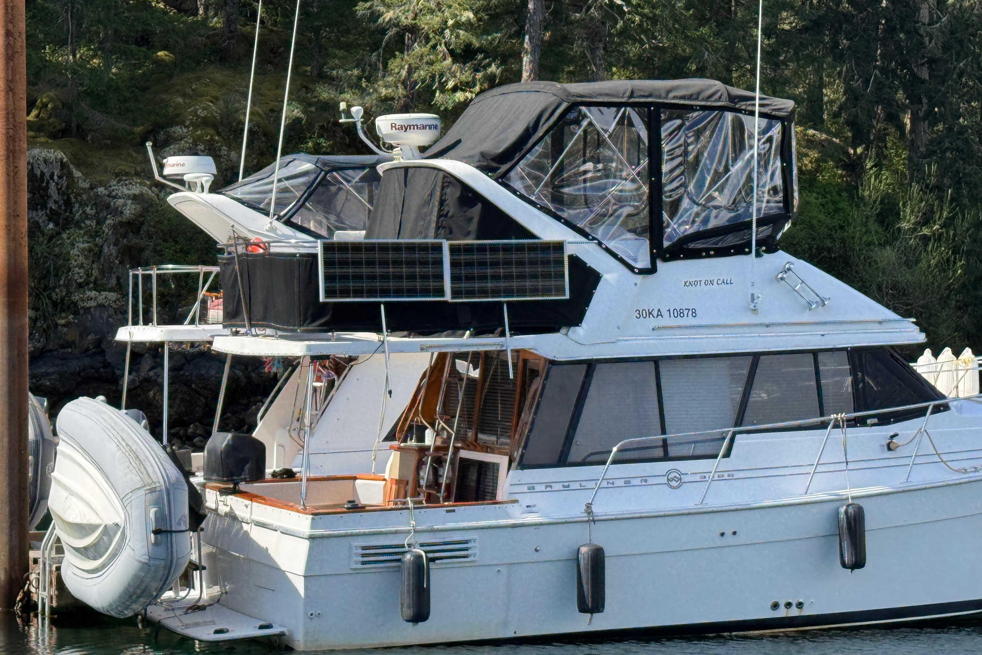 1995 Bayliner 3288 Motoryacht docked with solar panels and inflatable dinghy.