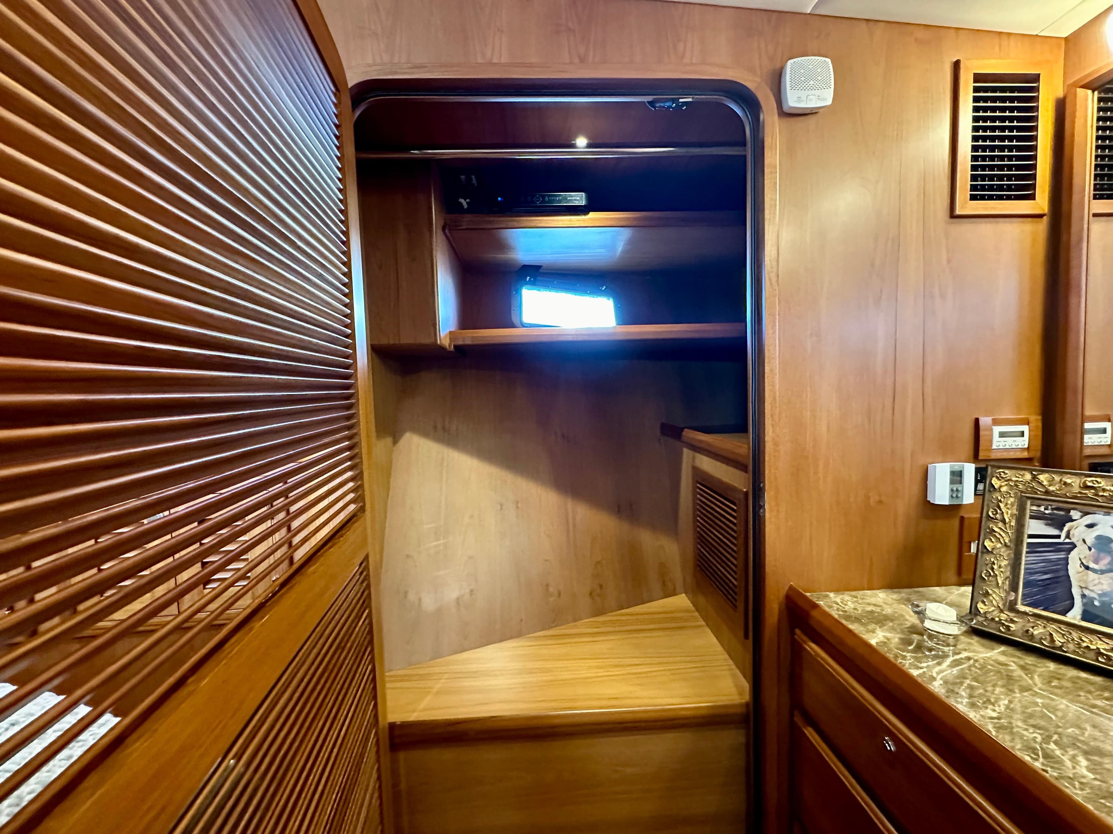 Interior of 2017 Kadey-Krogen 58EB yacht with wooden finishes and a small window.