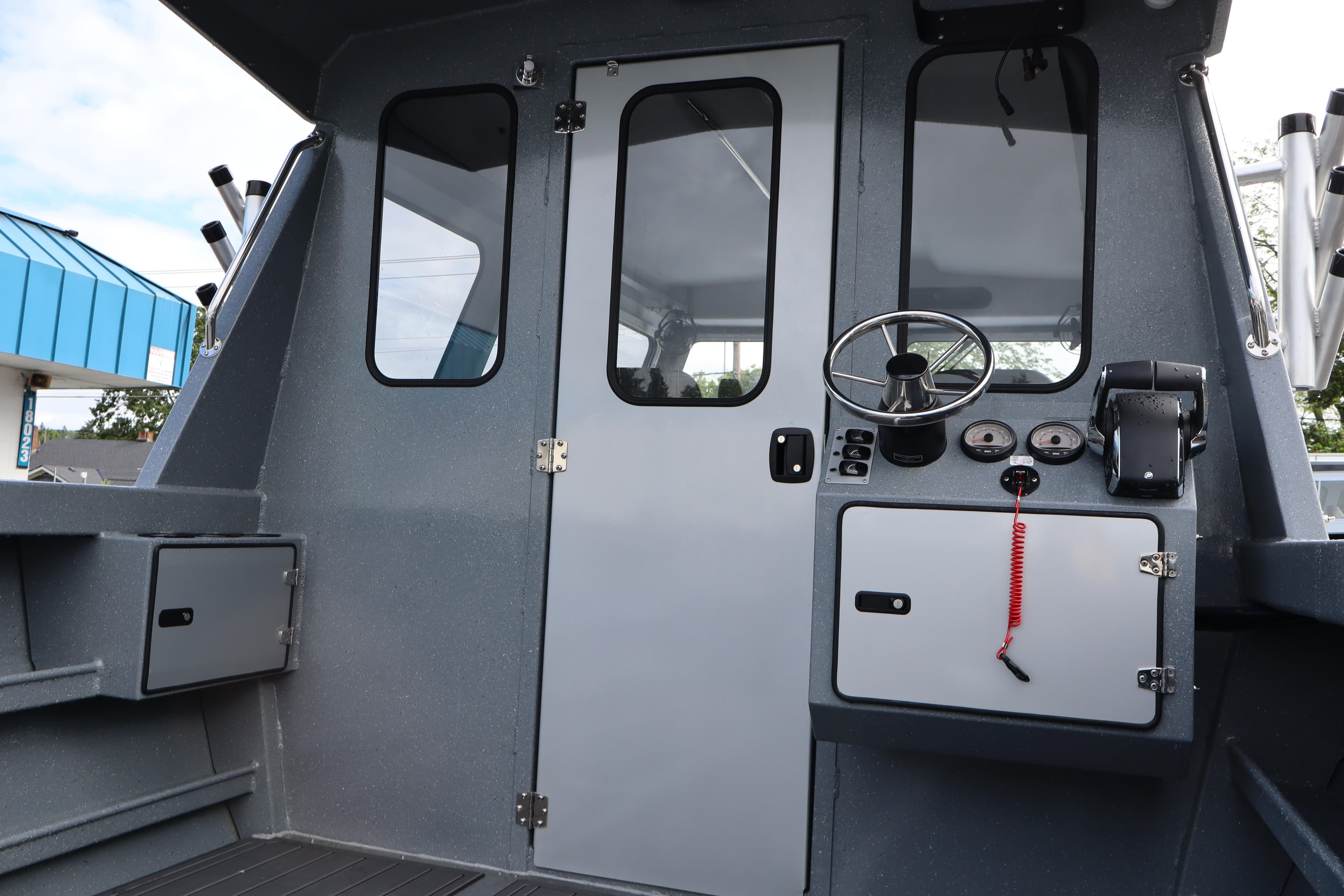 2026 KingFisher 2825 Coastal Express boat cockpit with steering wheel and control panel.