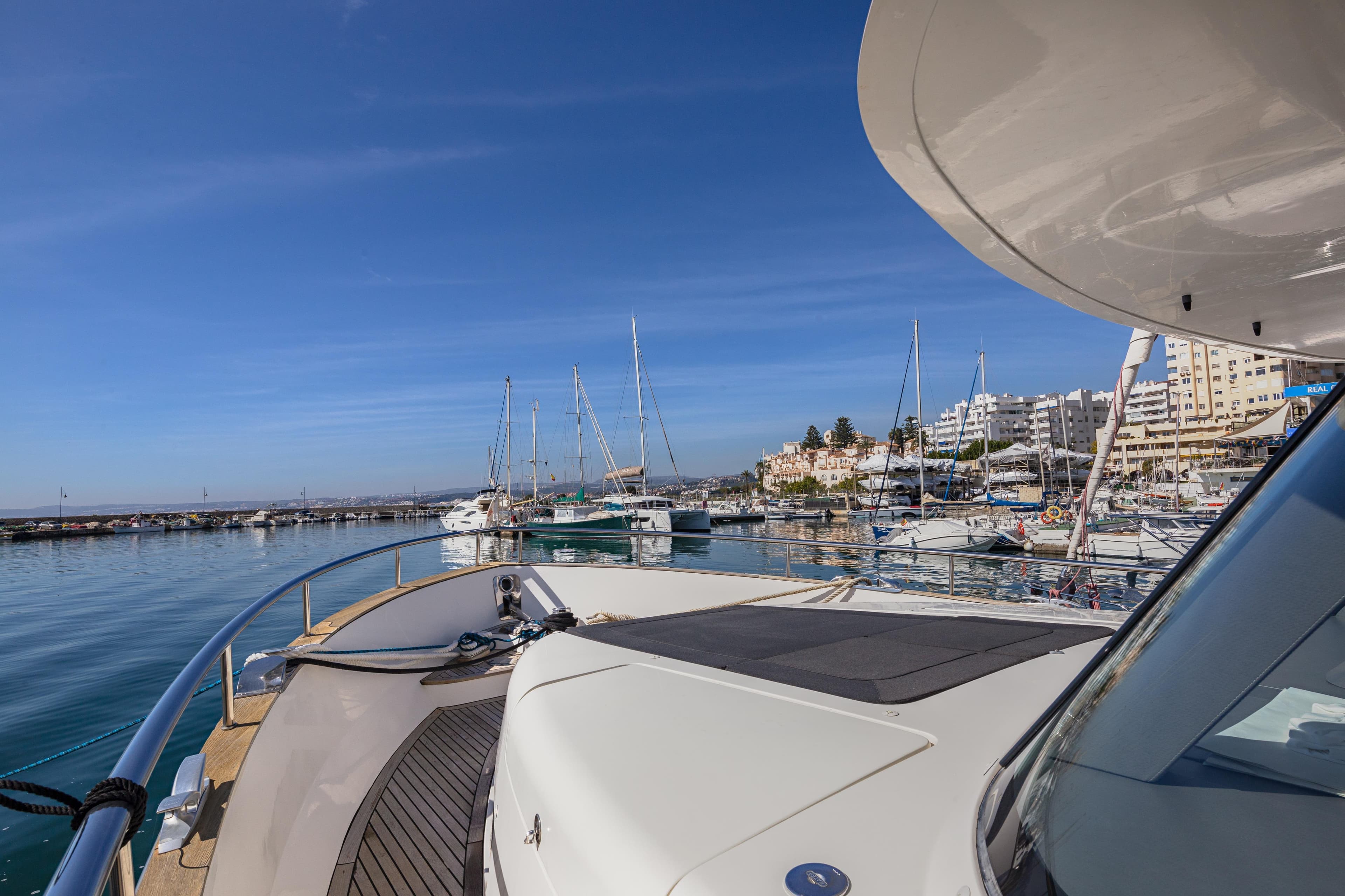 2016 Outer Reef Trident 620 yacht docked in a sunny marina with clear blue skies.