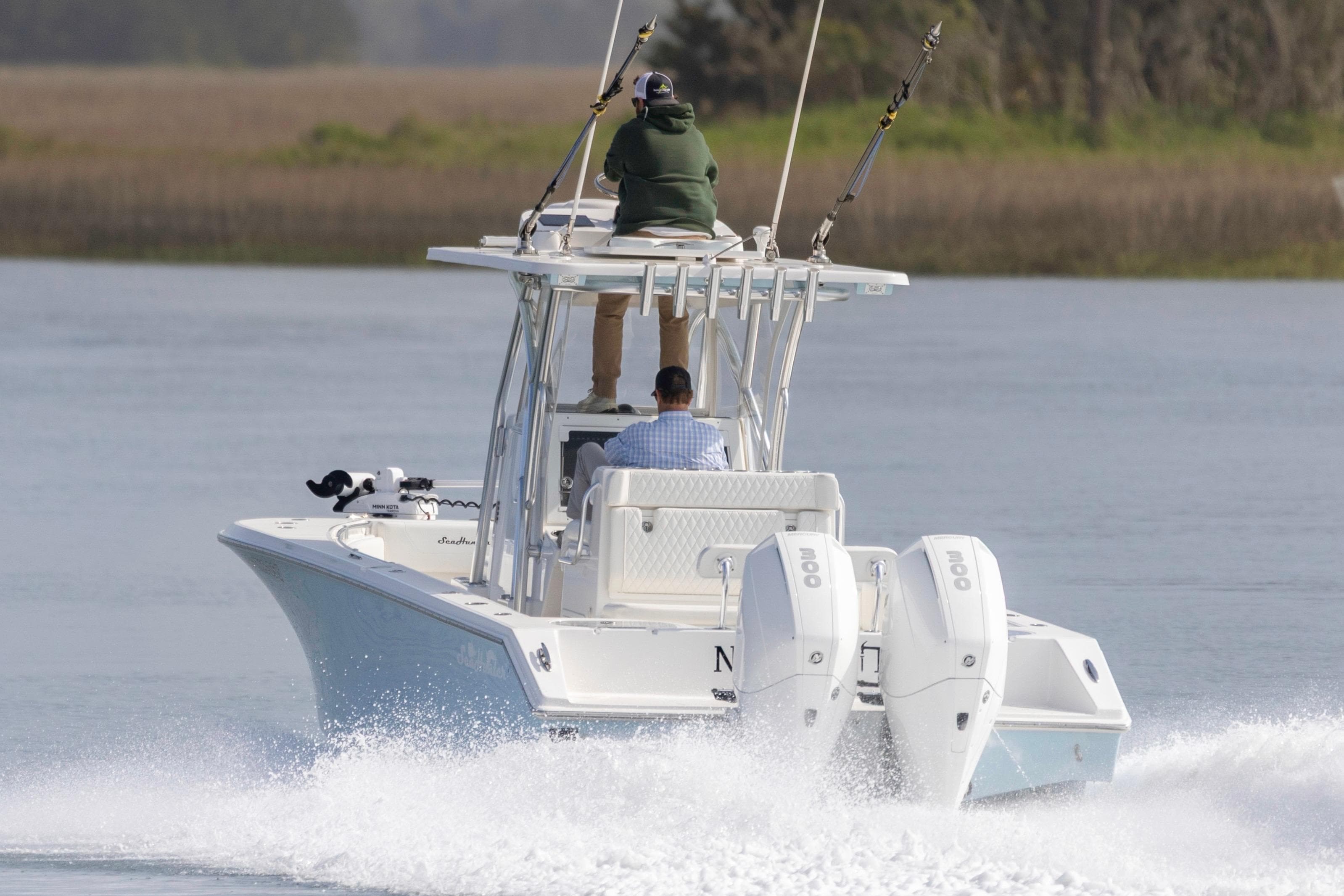 2021 SeaHunter 28 Floridian boat cruising on calm water with two passengers.