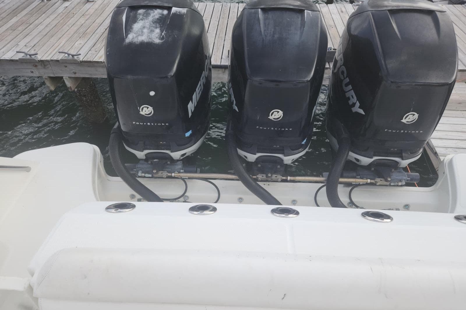 Triple Mercury outboard engines on a 2014 Boston Whaler 350 Outrage boat at dock.