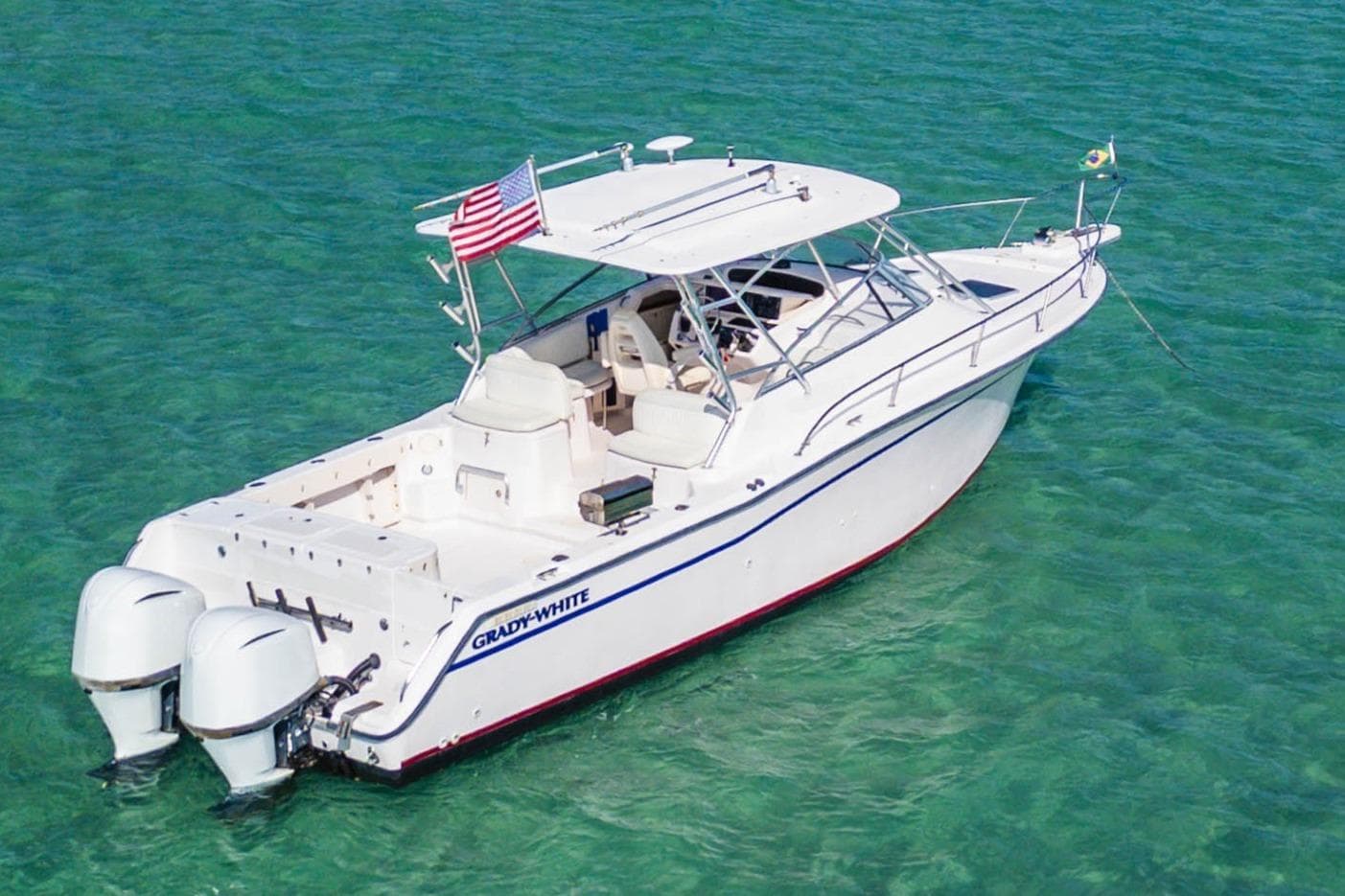 2003 Grady-White Express 330 boat on clear turquoise water, featuring dual outboard engines.
