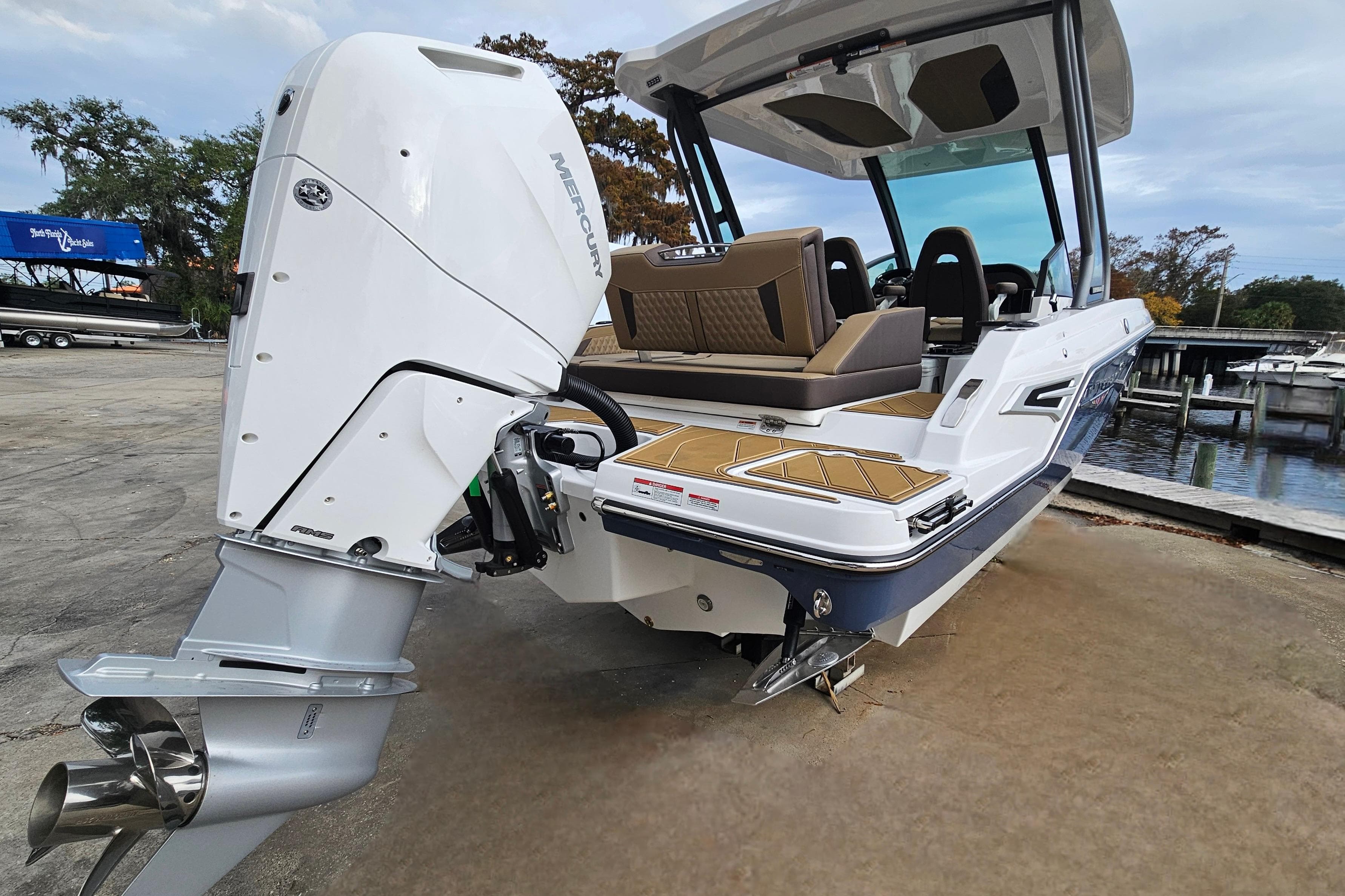 2026 Monterey Elite 27 OB boat with Mercury outboard engine, docked near a marina.