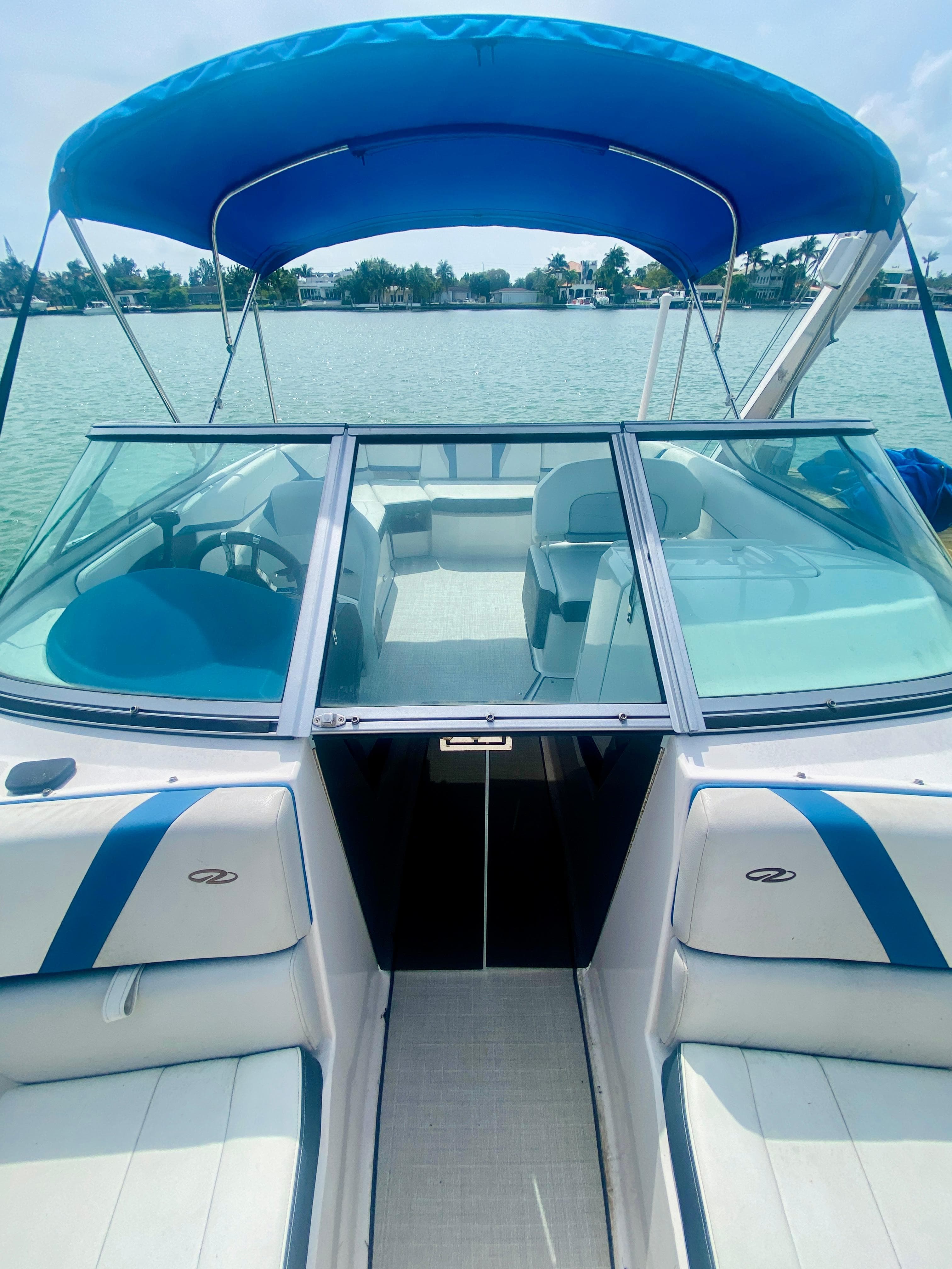 2016 Regal 22 FasDeck boat with blue canopy on a sunny day.