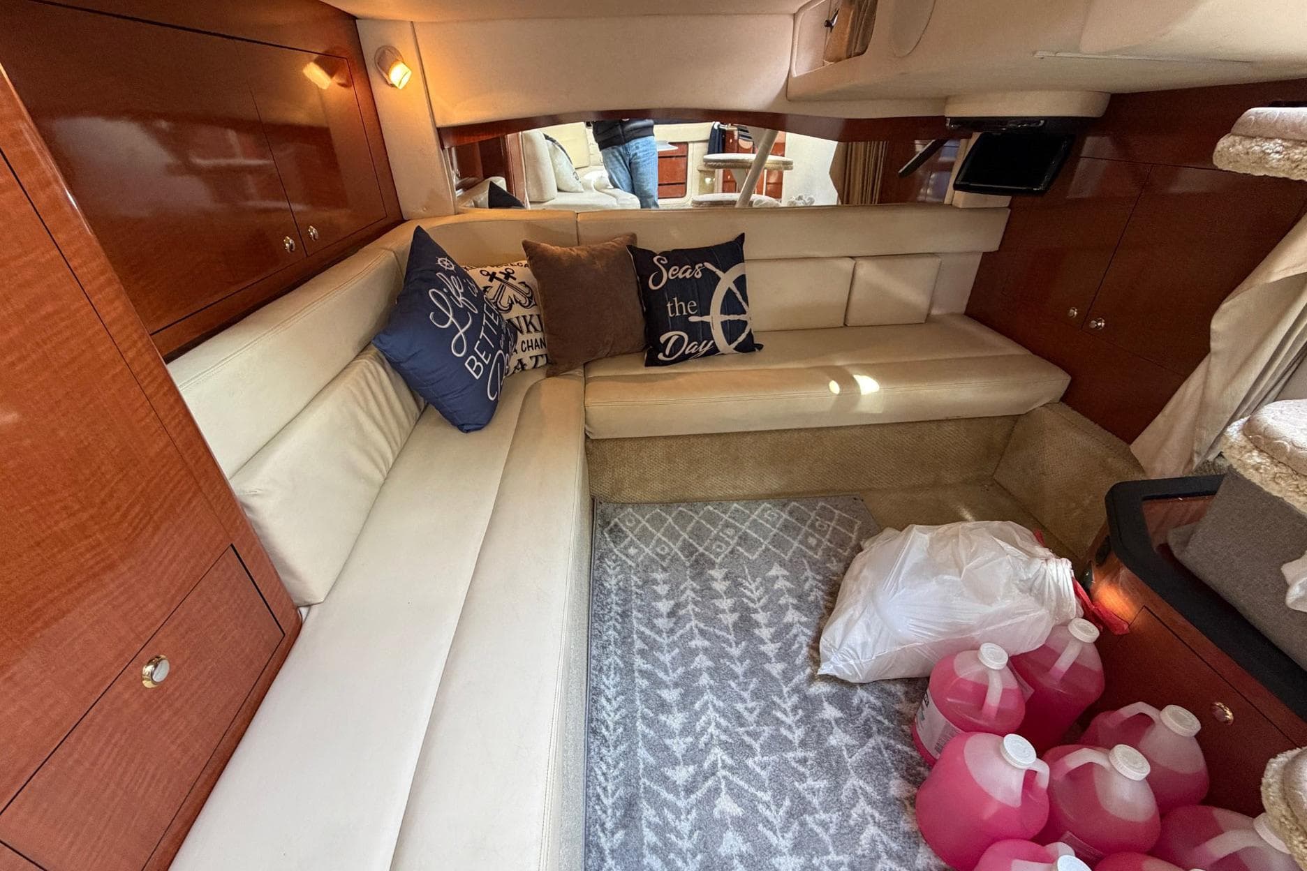 Interior of 2004 Sea Ray 340 Sundancer with cozy seating and nautical-themed pillows.