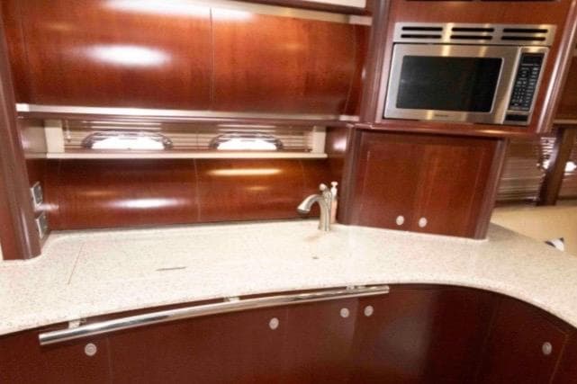 Luxurious kitchen area in a 2005 Sea Ray 500 Sundancer yacht with wood cabinetry.