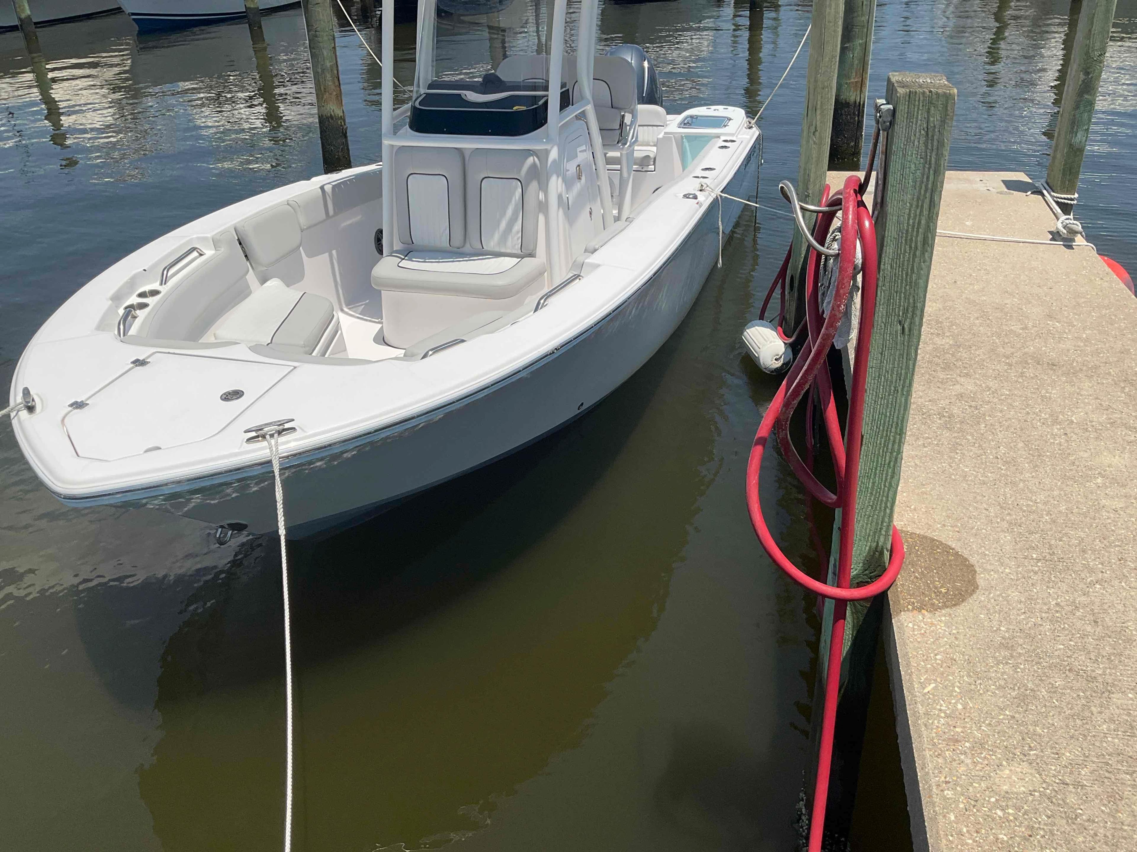 2023 Sea Fox 228 Commander boat docked at marina with red hose.