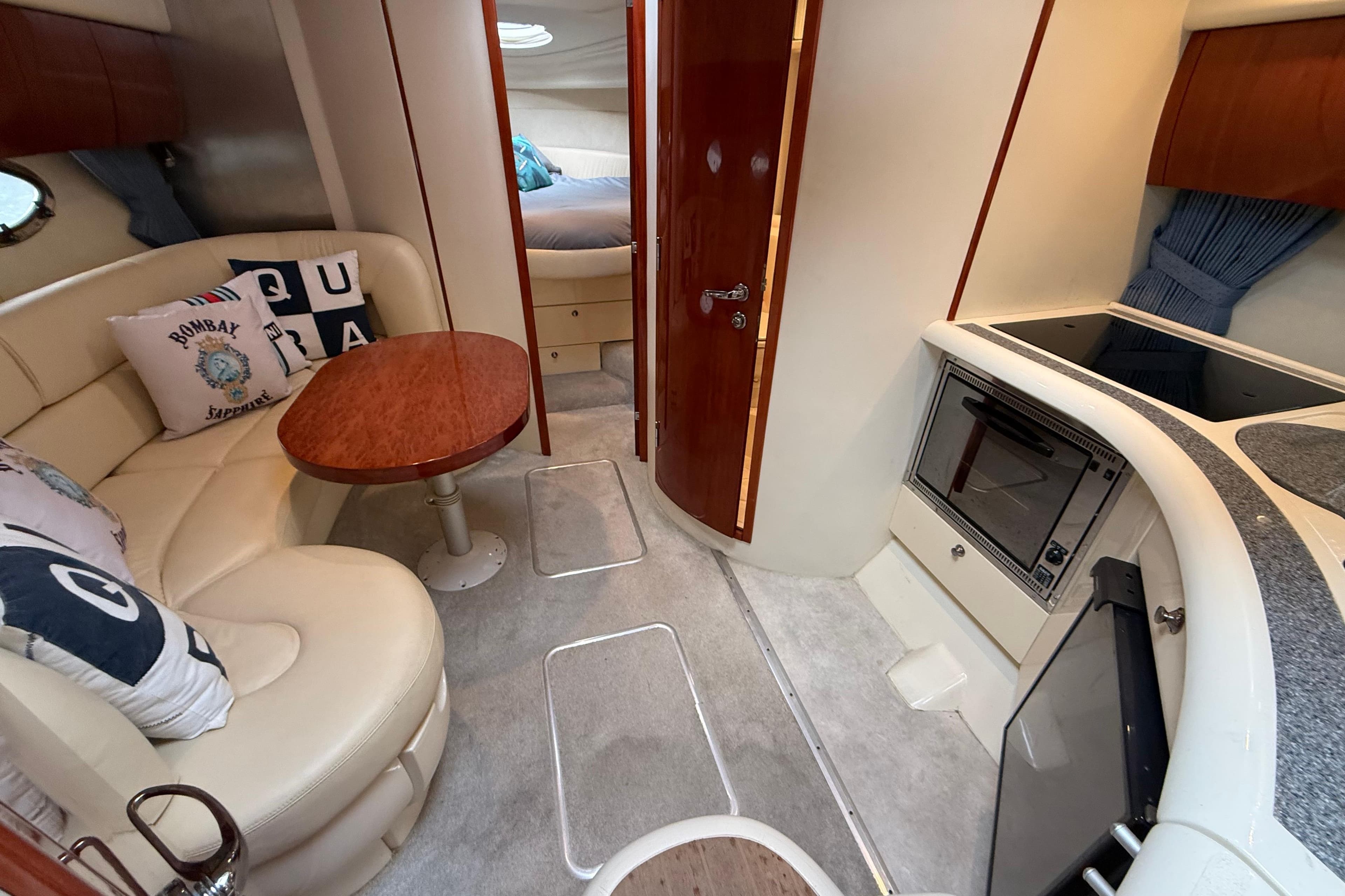 Interior of 2005 Fairline Targa 34 yacht with cozy seating and compact kitchen area.